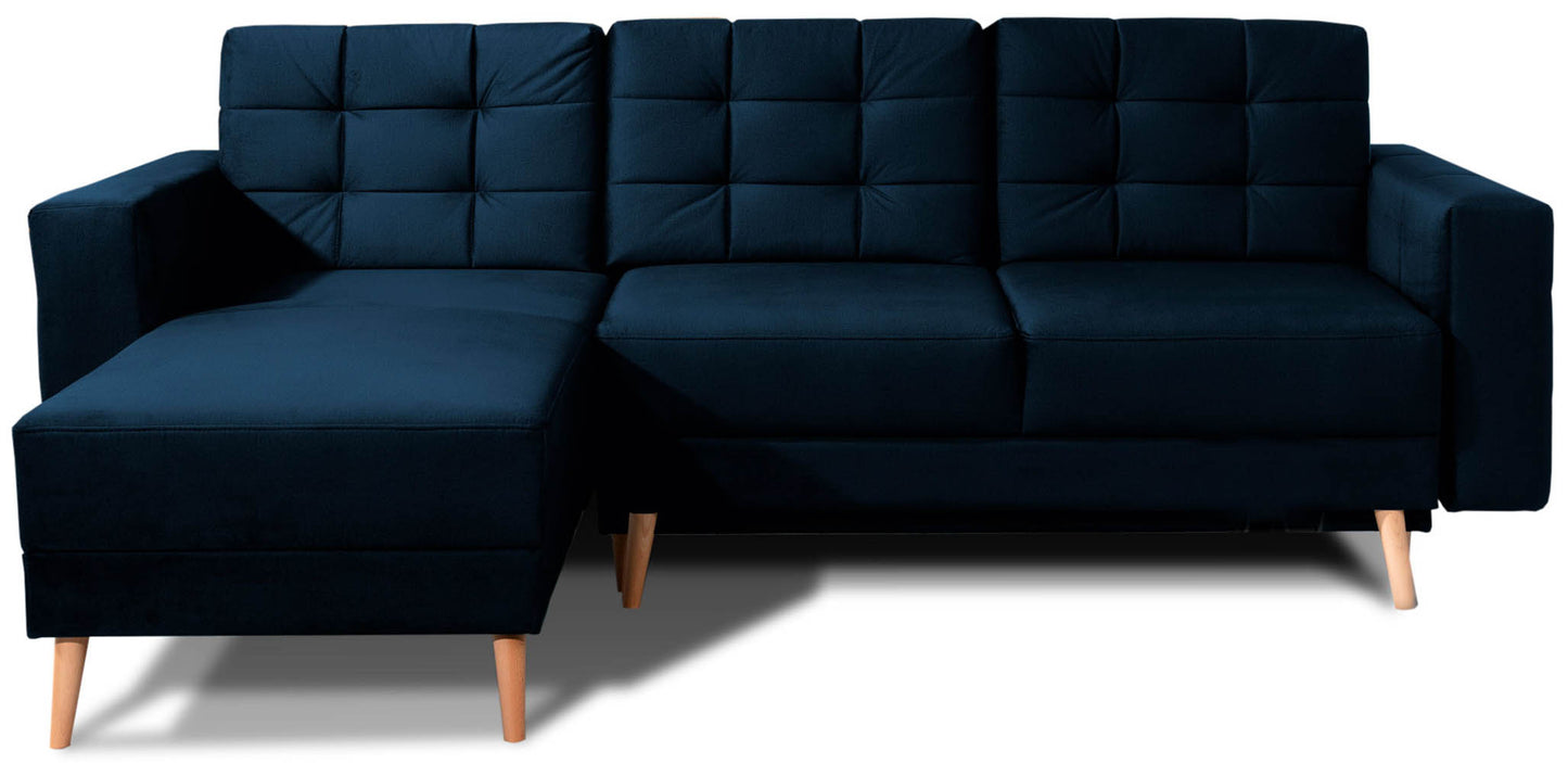 Narożnik Asgard L w kolorze Monolith 79 granatowy, układ uniwersalny, widok z przodu na tle białym. Pikowane oparcia, drewniane nóżki i nowoczesna forma.