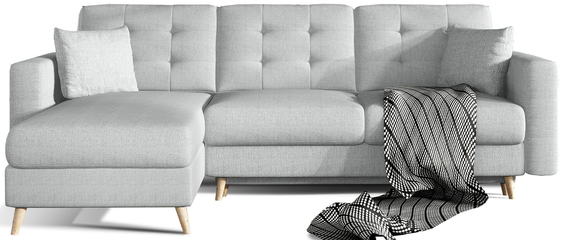 Beżowy narożnik Asgard L w tkaninie Solid 09, układ uniwersalny, widok na wprost – pikowane oparcia, drewniane nóżki i dekoracyjny koc w czarno-białym wzorze.