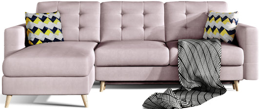 Narożnik Asgard L w kolorze Soro 61 jasnoróżowy z dekoracyjnymi poduszkami Zigzag 53. Model w układzie uniwersalnym, tapicerowany, z pikowanym oparciem i drewnianymi nóżkami.