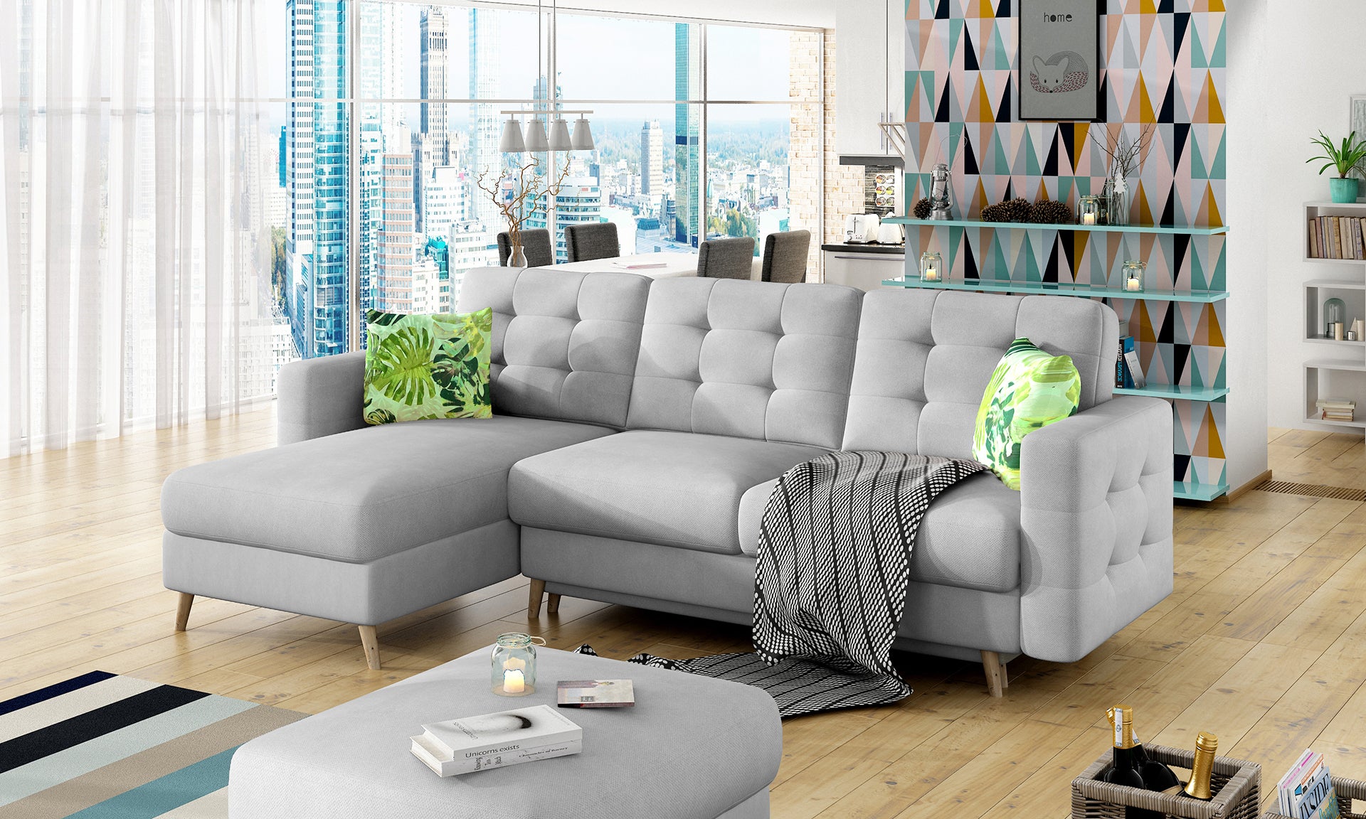 Narożnik Asgard L Soro 83 w układzie lewostronnym, ustawiony w jasnym salonie z dużymi oknami i miejskim widokiem – dekoracyjna poduszka Jungle 32 i nowoczesne dodatki.