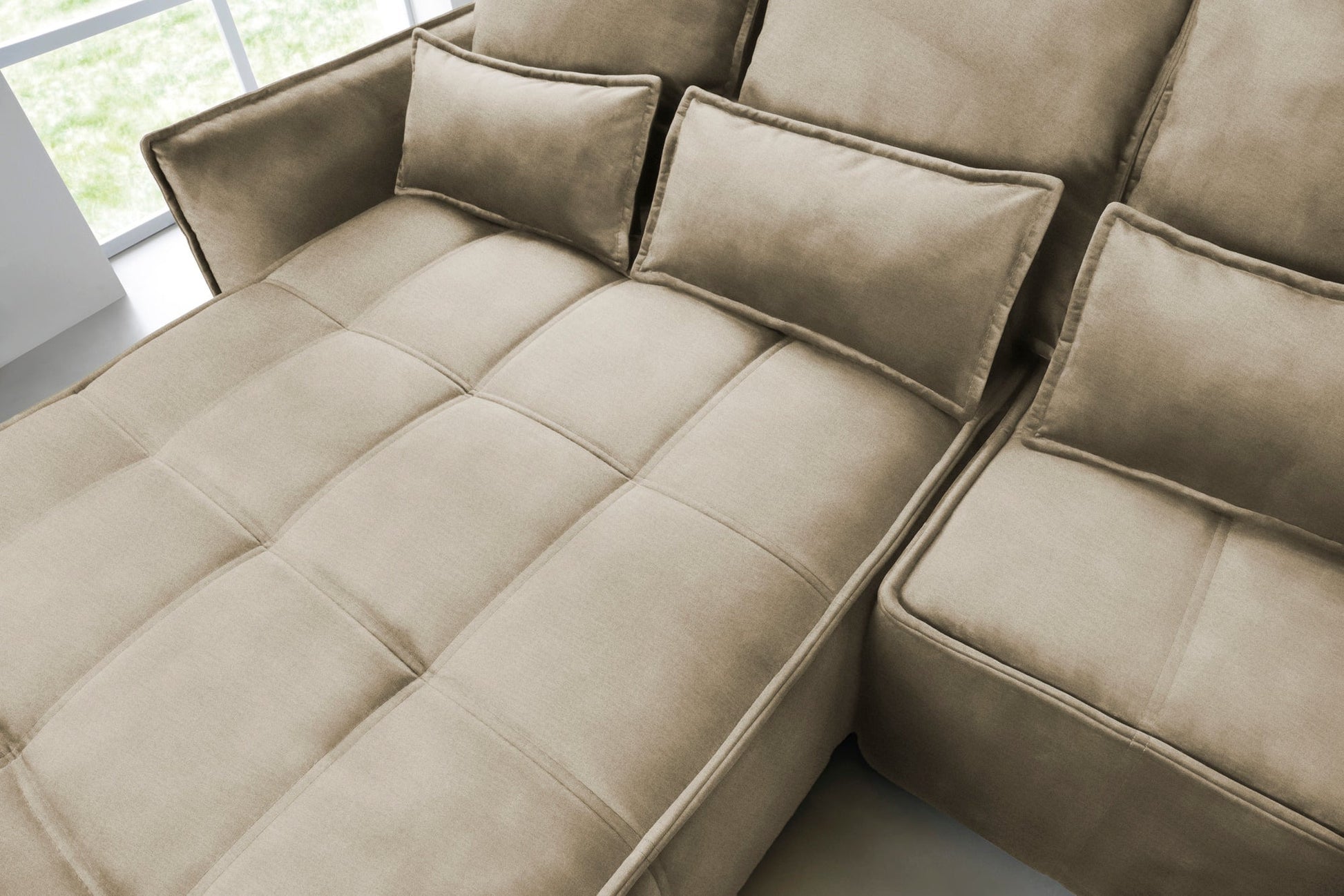 Zbliżenie na pikowaną powierzchnię siedziska i prostokątne poduszki narożnika Campo w układzie lewym, tkanina Nube 20 beżowy.