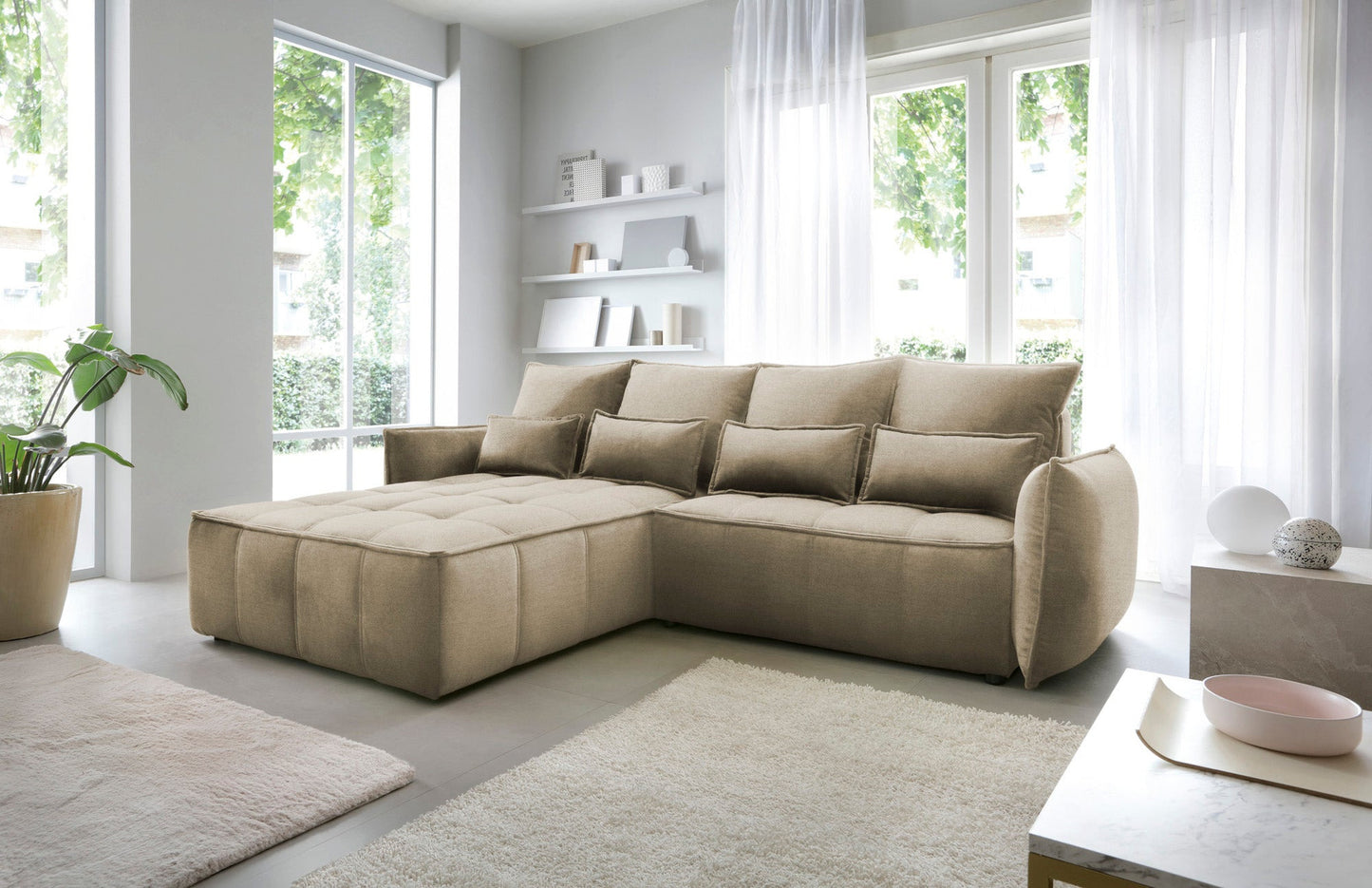 Narożnik Campo w układzie lewym, tapicerka Nube 20 beżowy, widok boczny w nowoczesnym wnętrzu z dywanem i stolikiem kawowym.