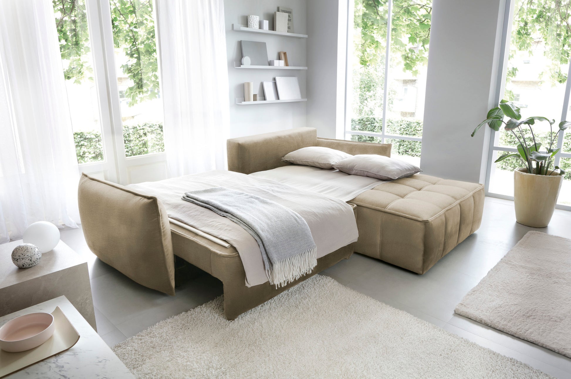 Narożnik Campo w układzie prawym, tkanina Nube 04 szary, rozłożony jako wygodne łóżko z narzutą i poduszkami w przestronnym salonie.