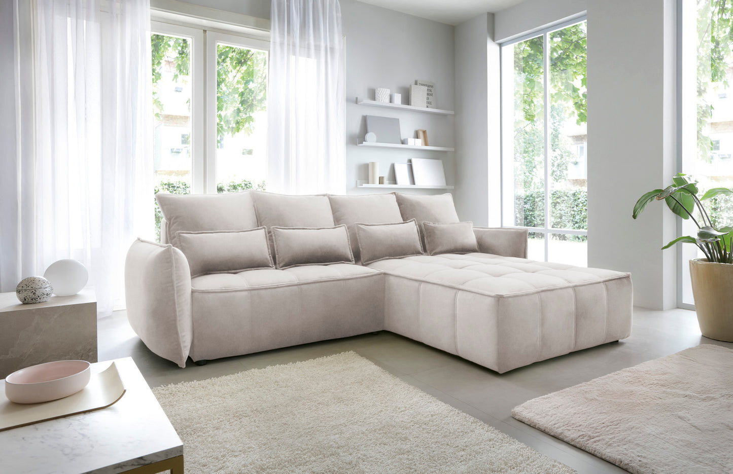 Narożnik Campo Relax 18 beżowy w prawostronnym układzie, prezentowany w stylowej aranżacji wnętrza z widocznym pikowanym pufem.