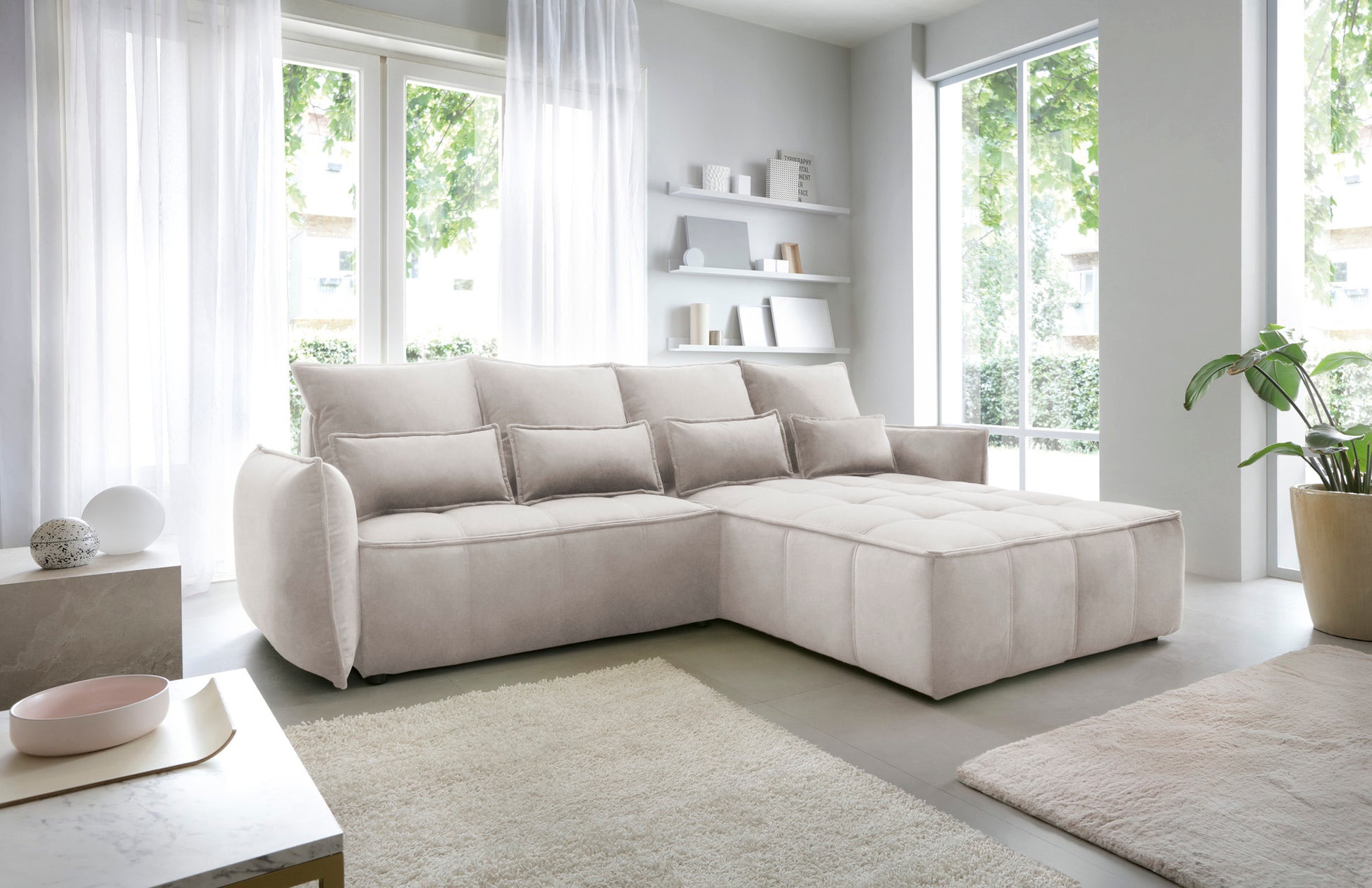 Narożnik Campo Relax 18 beżowy w prawostronnym układzie, prezentowany w stylowej aranżacji wnętrza z widocznym pikowanym pufem.