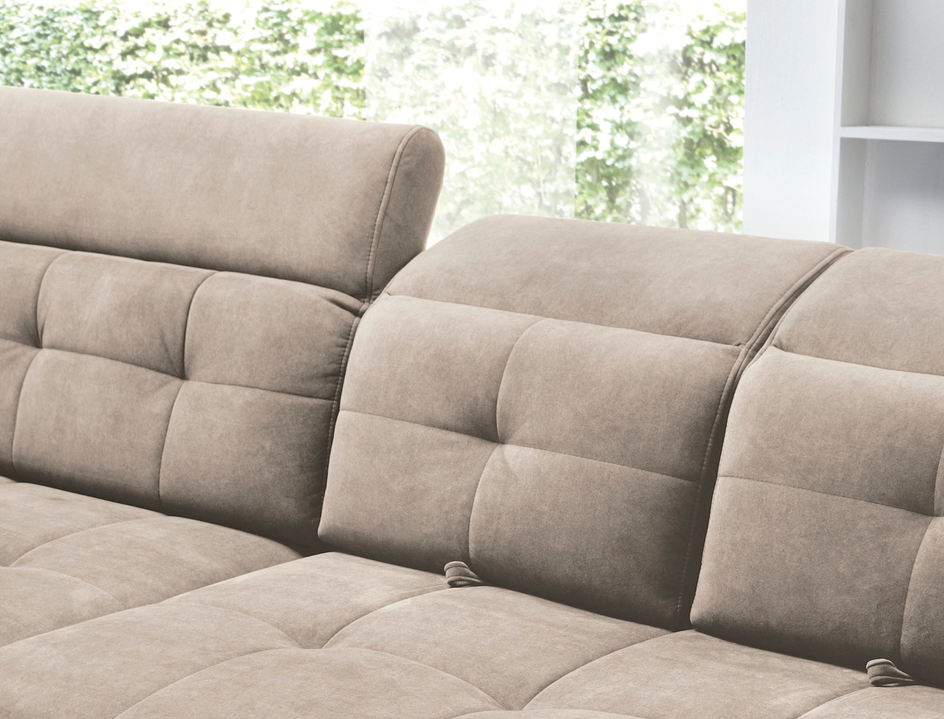 Detal pikowanego siedziska i miękkiego, zaokrąglonego podłokietnika narożnika Inferne Relax 20 beżowego w układzie lewym, ukazujący fakturę tkaniny.