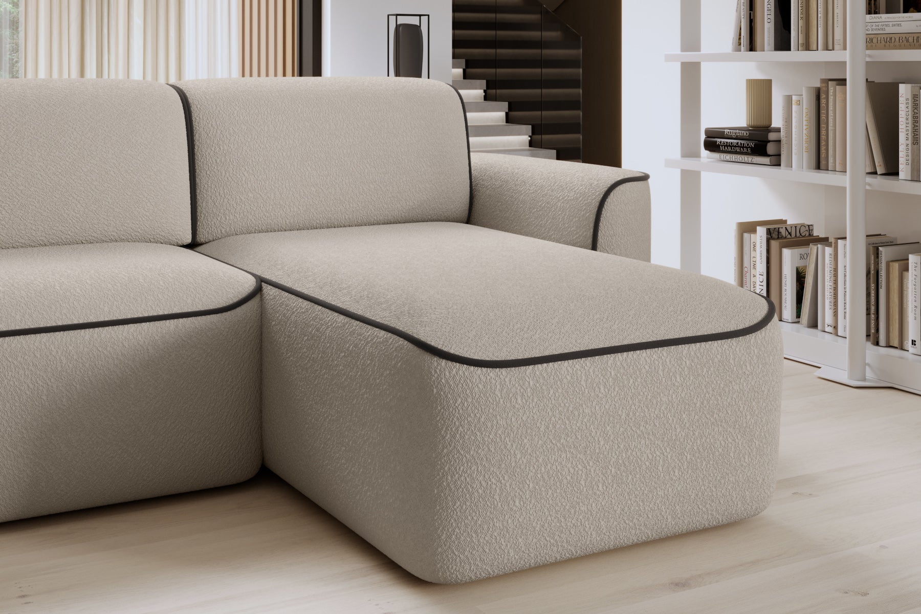 Zbliżenie przedniej krawędzi szezlongu po prawej stronie narożnika Ume, miękka tapicerka Royal 18 beżowy obwiedziona elegancką lamówką w kolorze brązu.