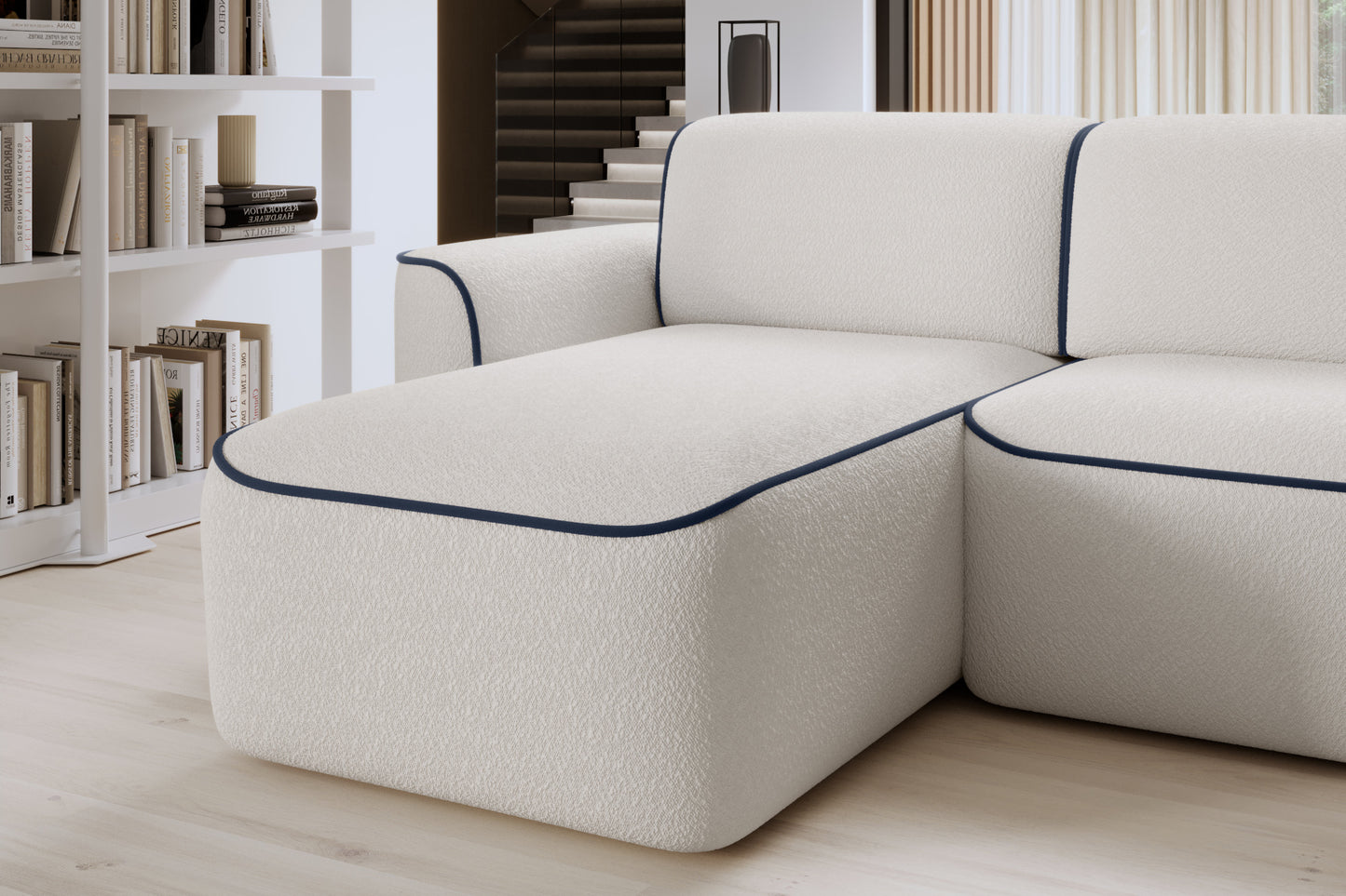 Zbliżenie lewej otomanki narożnika Ume – zaokrąglony narożnik z fakturowaną białą tkaniną i granatową lamówką.