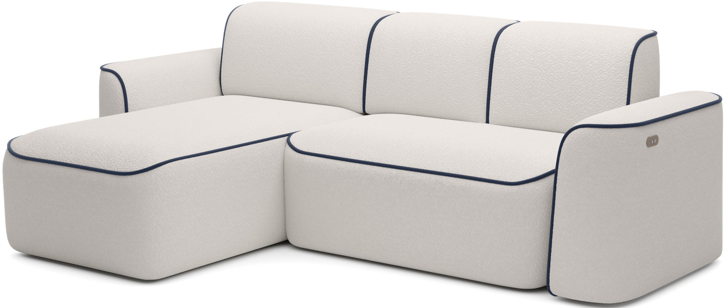 Perspektywiczny, lekko ukośny widok narożnika Ume na białym tle, fakturowane bouclé Royal 01 z ciemnogranatowym wykończeniem Velvetmat 40.