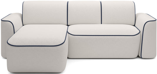 Przód narożnika Ume w układzie lewym na białym tle, biała tapicerka bouclé Royal 01 z kontrastową lamówką Velvetmat 40 granatowy.