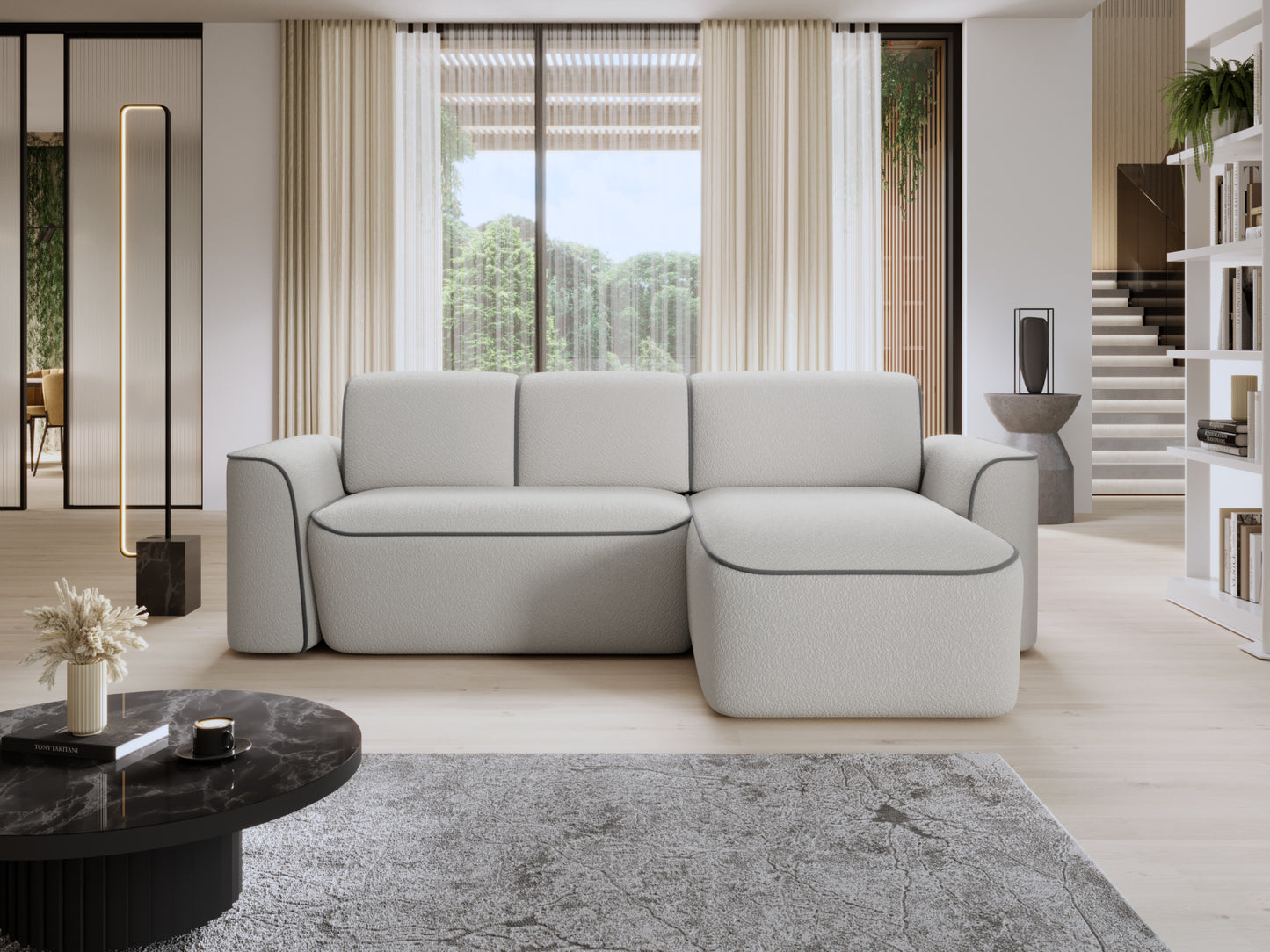Narożnik Ume z prawą otomanką we wnętrzu salonu z dużym oknem, jasną podłogą i marmurowym stolikiem, biała tkanina bouclé z szarą lamówką.