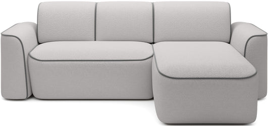 Frontowy widok narożnika Ume w układzie prawym na białym tle, tapicerka bouclé Royal 03 biały z kontrastową lamówką Velvetmat 04 szary.