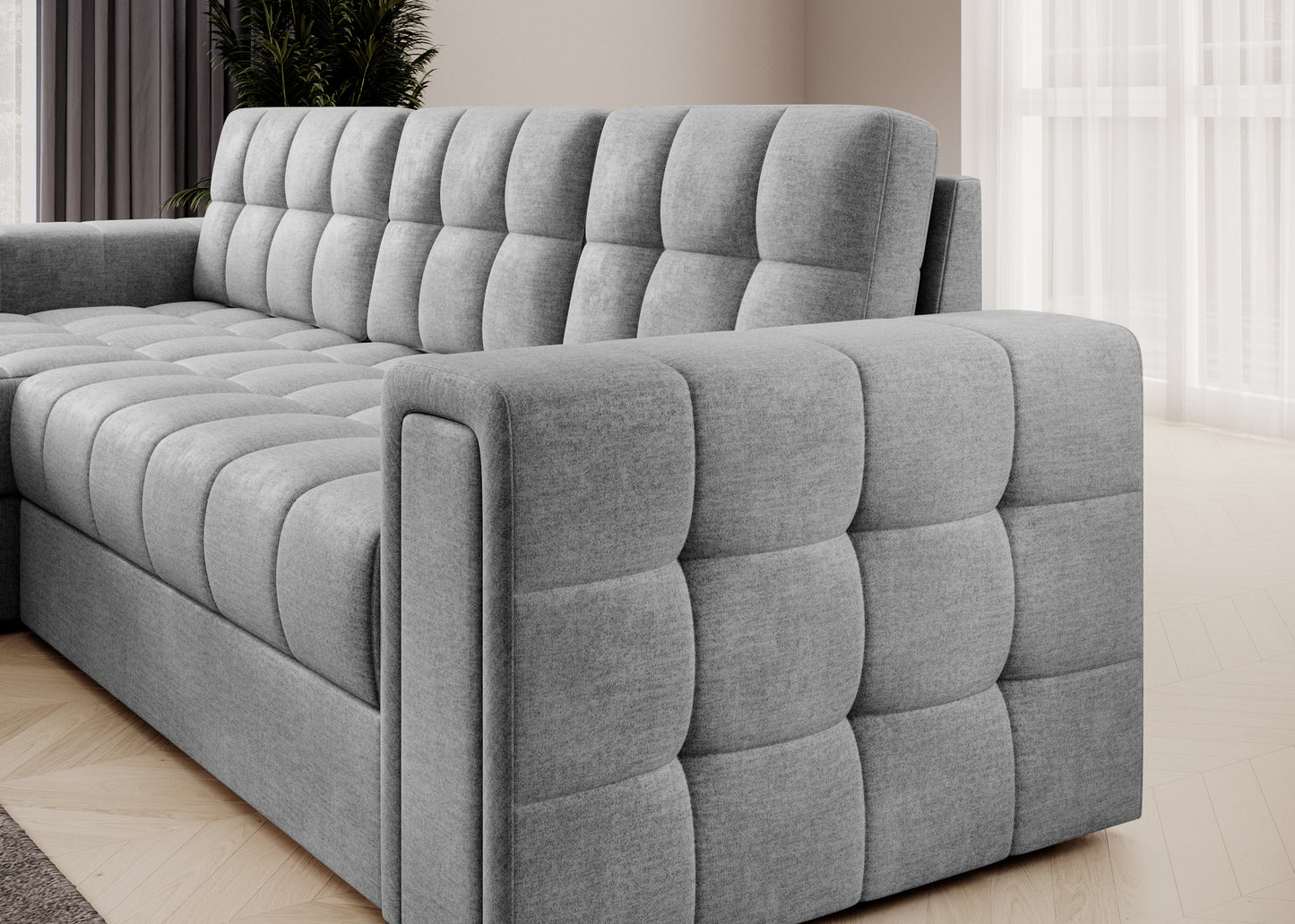 Boczny widok narożnika Blenvi w tkaninie Monolith 84 jasnoszarym, z pikowanymi panelami na podłokietniku i siedzisku.