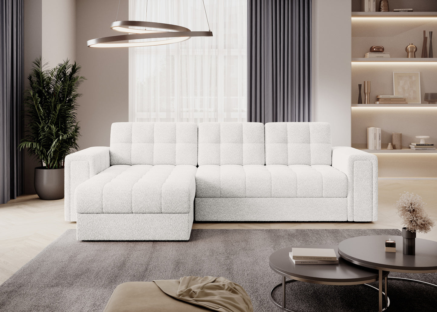 Sofa narożna w tkaninie bouclé Royal 01 biały w nowoczesnym salonie z zasłonami, regałem i oświetleniem LED.