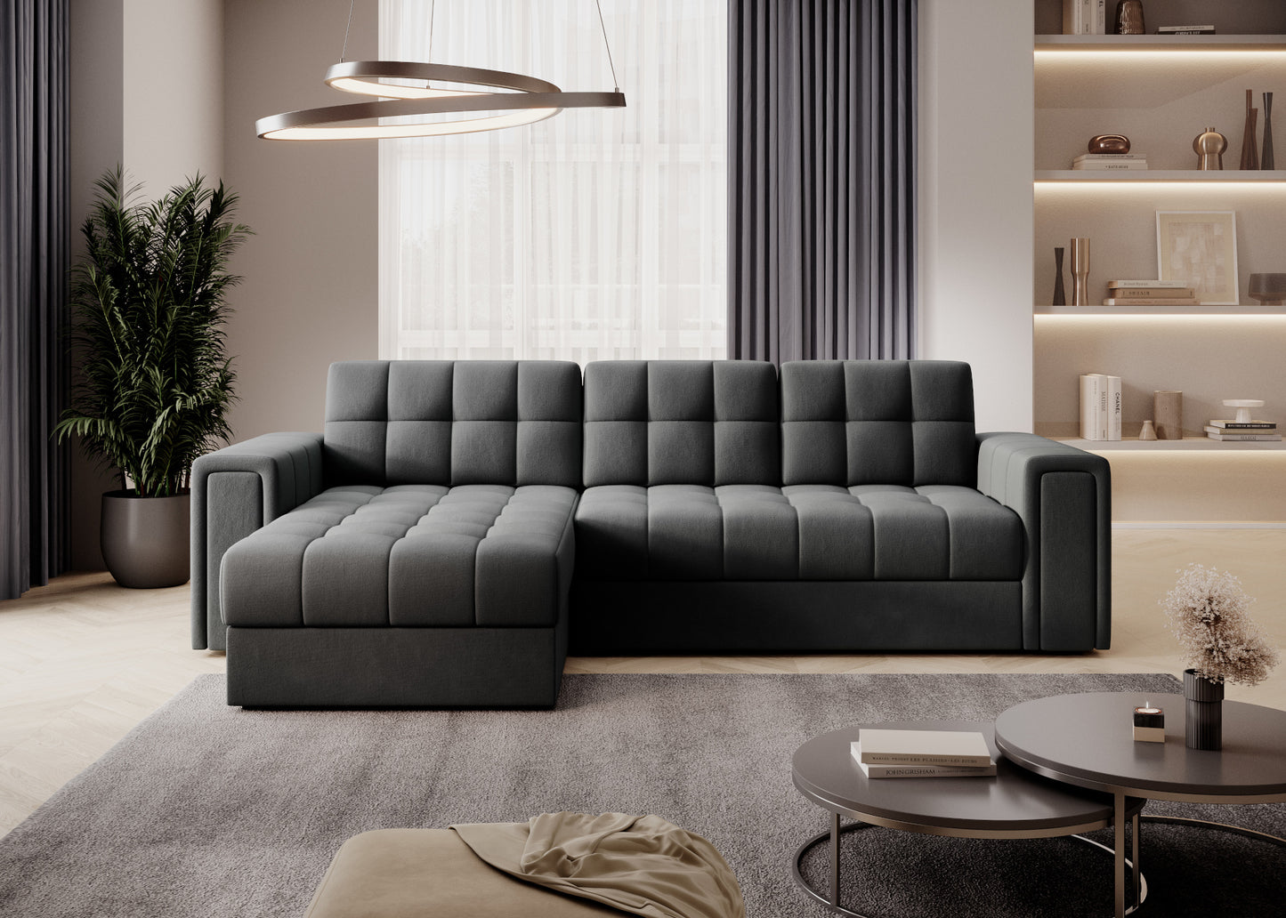 Sofa narożna w tkaninie Sola 06 szary z pikowanym siedziskiem, nowoczesny salon z regałem, zasłonami i oświetleniem sufitowym LED.