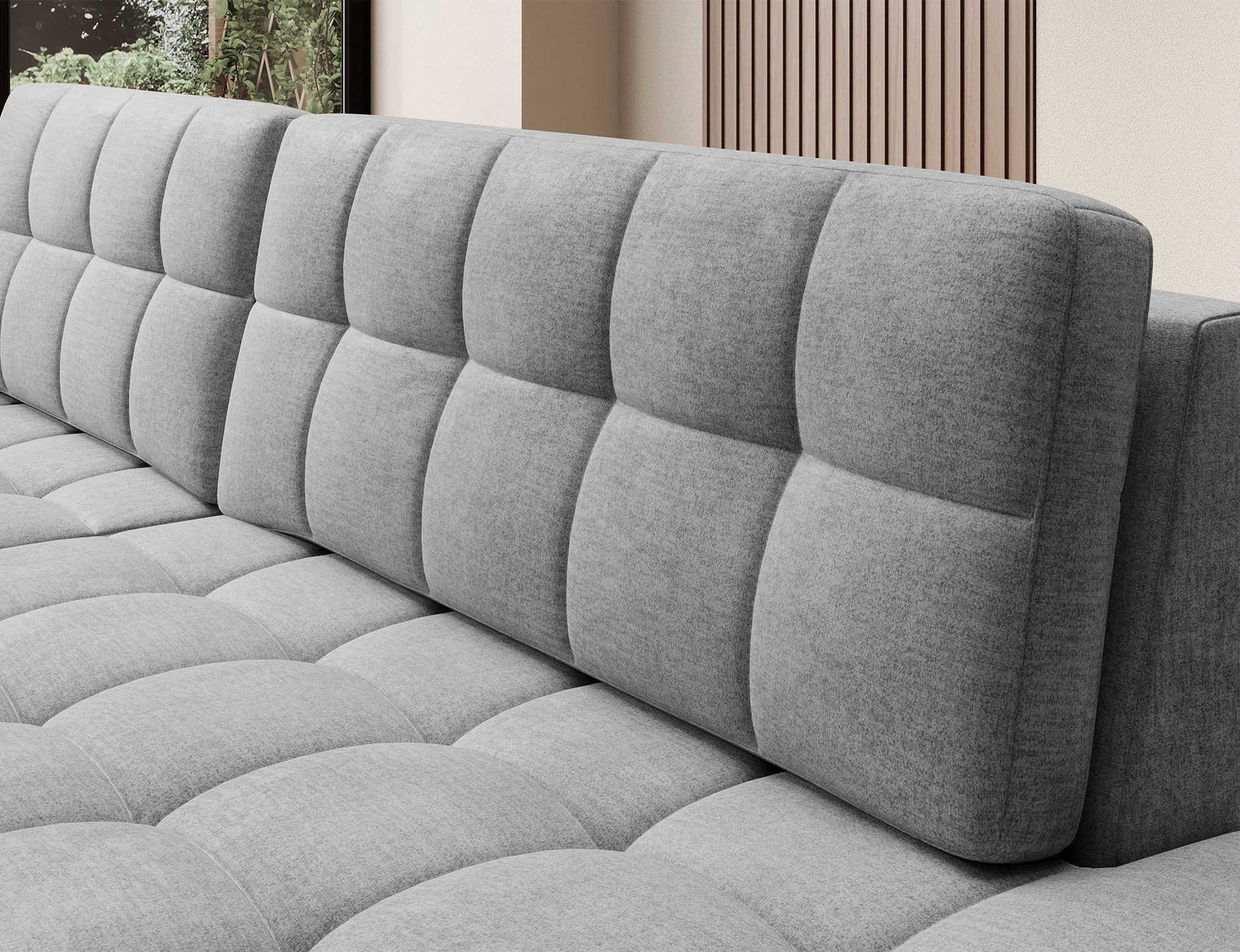 Szare oparcie narożnika Blezalt Monolith 85 z dużymi, miękkimi przeszyciami, widok z boku na pikowane poduszki i siedzisko.