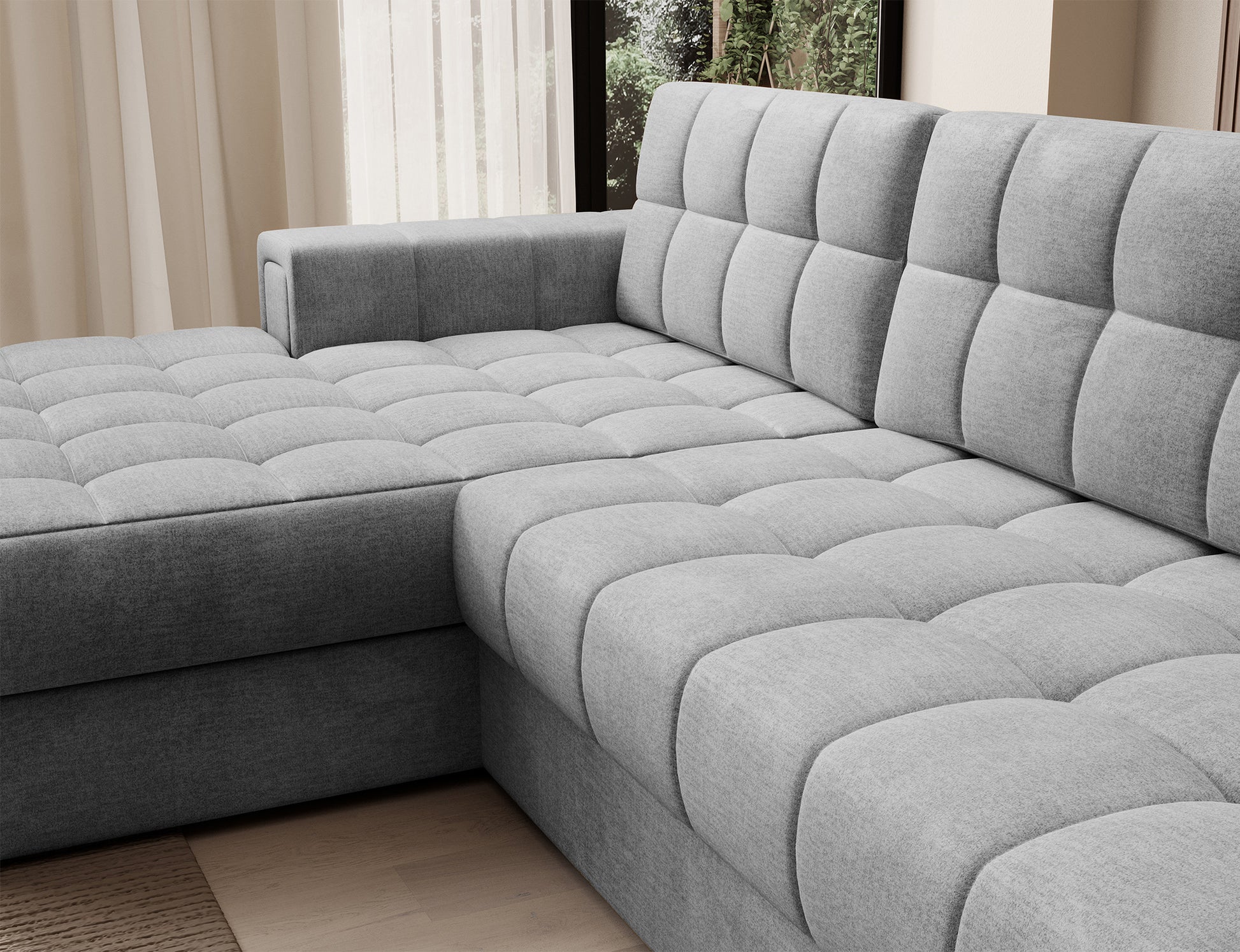 Szare, pikowane siedzisko narożnika Blezalt Monolith 85 z miękkim oparciem, widok z boku w nowoczesnym, jasnym wnętrzu.