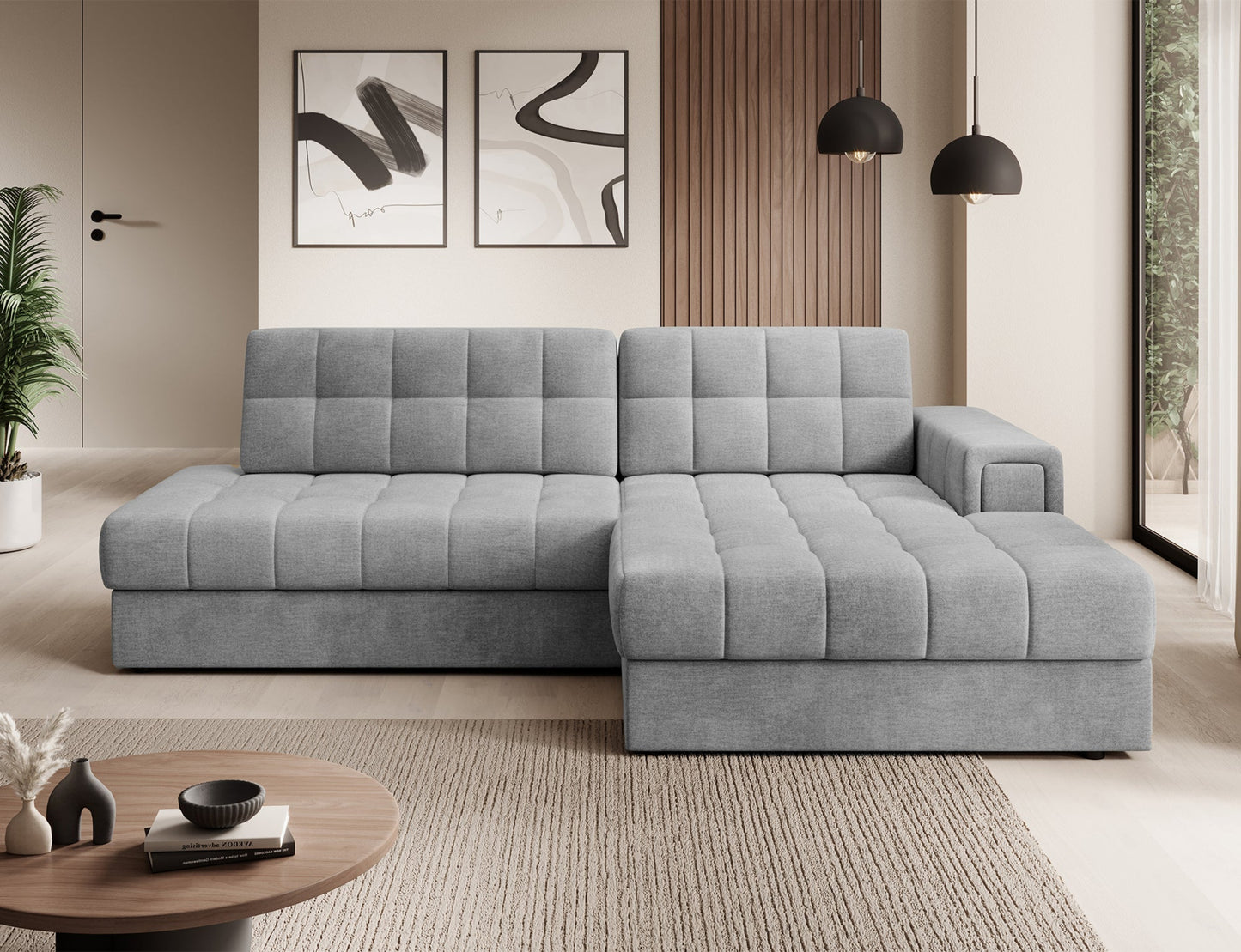 Szary narożnik Blezalt Monolith 85 prawy w nowoczesnym salonie, pikowany, z szerokim podłokietnikiem, ustawiony przy ścianie.