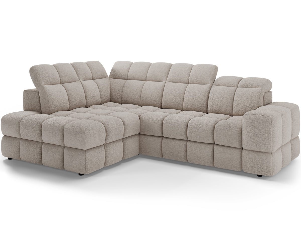 Narożnik Bronon lewy jasnobeżowy w ujęciu pod kątem, z szerokimi podłokietnikami, segmentowymi przeszyciami i zaokrąglonymi krawędziami.
