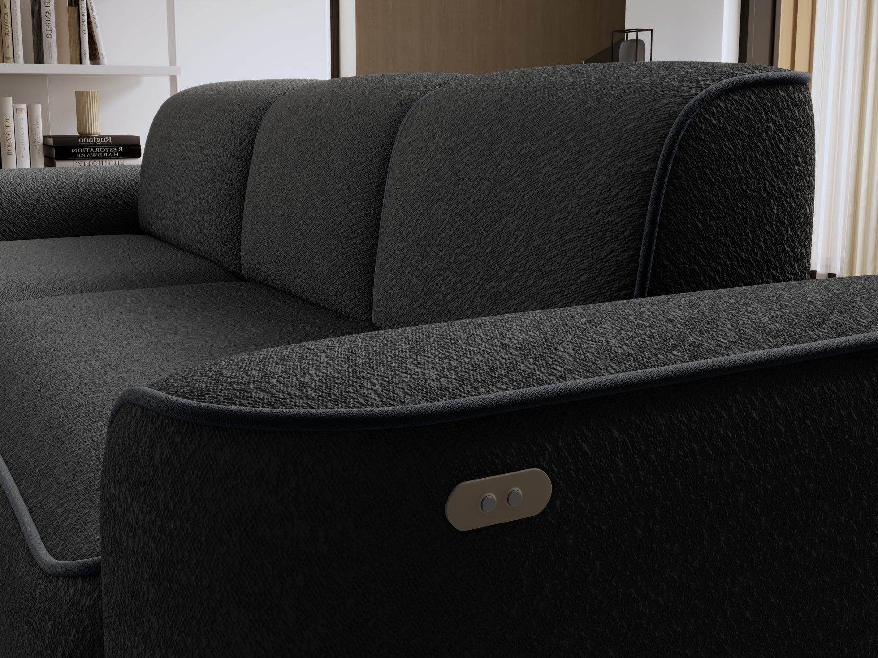 Zbliżenie na lewy podłokietnik narożnika Ume z wbudowanym panelem sterowania, fakturowana czarna tkanina i lamówka w ciemnym odcieniu szarości.