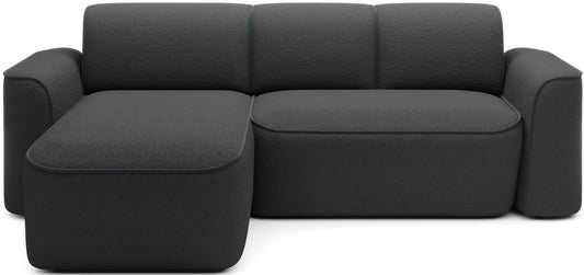 Frontowy, studyjny widok narożnika Ume w układzie lewym z szezlongiem po lewej stronie, tapicerka bouclé Royal 05 czarny z lamówką Velvetmat 06 ciemnoszary.