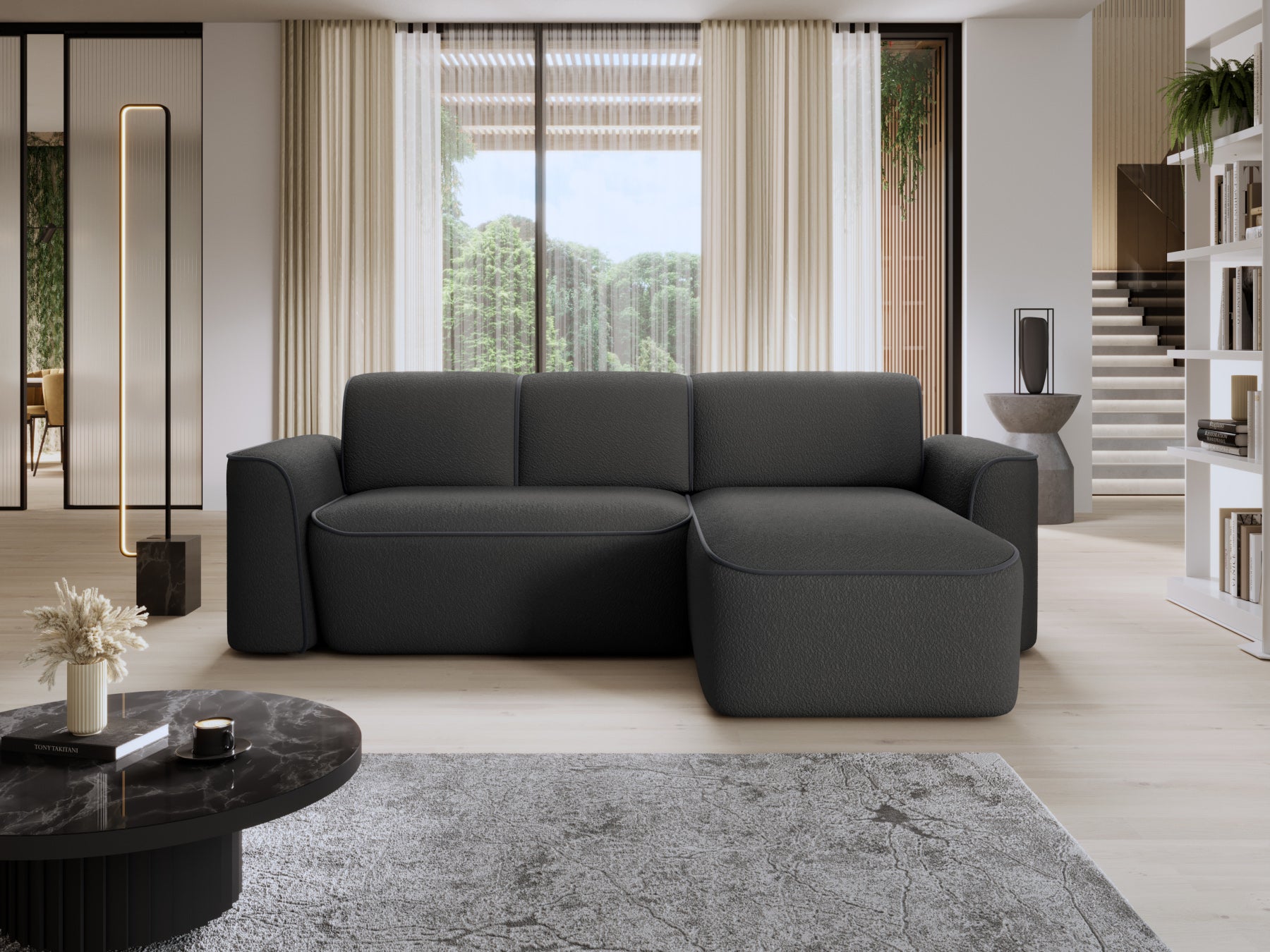 Narożnik Ume z szezlongiem po prawej w nowoczesnym salonie przy dużych oknach, czarne bouclé zestawione z kontrastową lamówką ciemnoszarą.