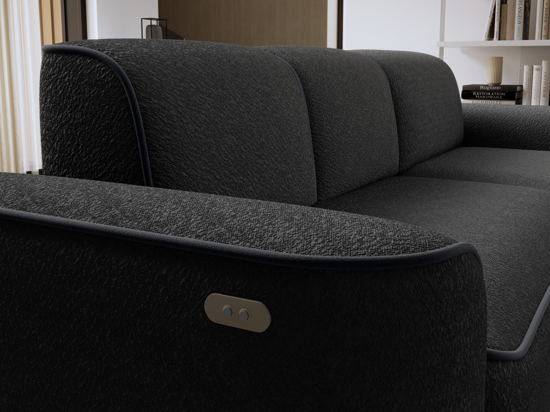 Zbliżenie na prawy podłokietnik narożnika Ume z wbudowanym przyciskiem sterowania, fakturowana tkanina Royal 05 czarny i lamówka Velvetmat 06 ciemnoszary.