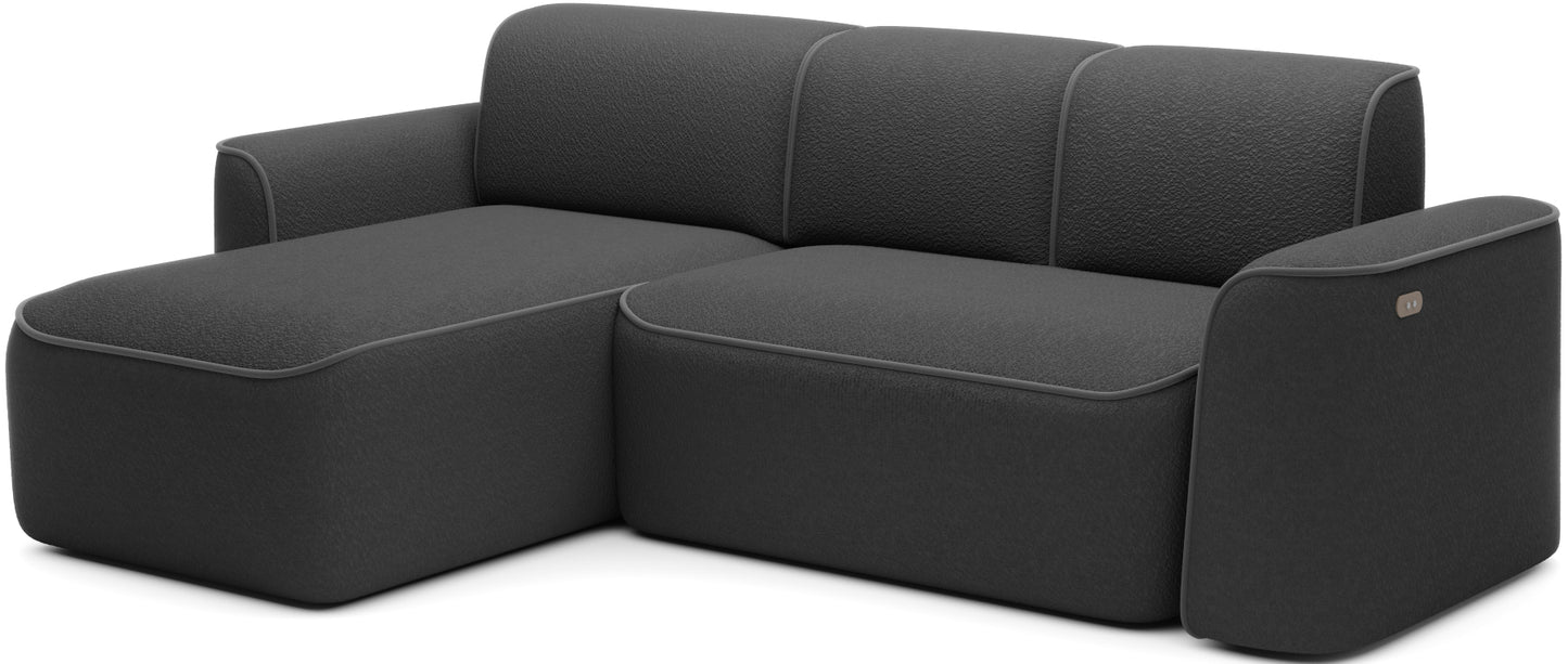 Narożnik Ume w układzie lewym ustawiony w nowoczesnym salonie przy dużym oknie, czarna tkanina i subtelna szara obwódka.