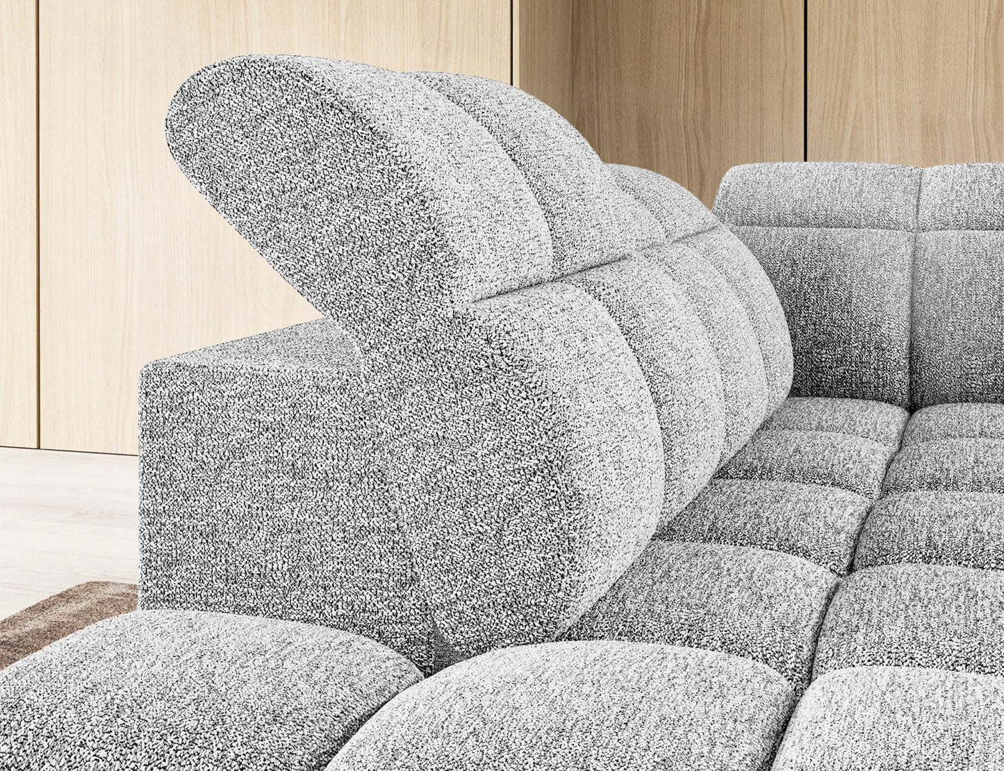 Zbliżenie na zagłówek narożnika Falconn Coralline 01 w pozycji podniesionej, pokryty jasną tkaniną bouclé i ozdobiony pikowaniem.