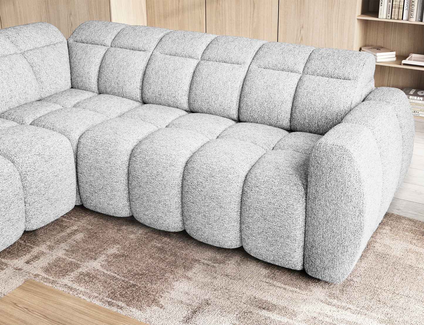 Zbliżenie na narożnik Falconn Coralline 01 z wsuniętym siedziskiem, pokazujące pikowaną strukturę i zaokrąglone linie w tkaninie bouclé.