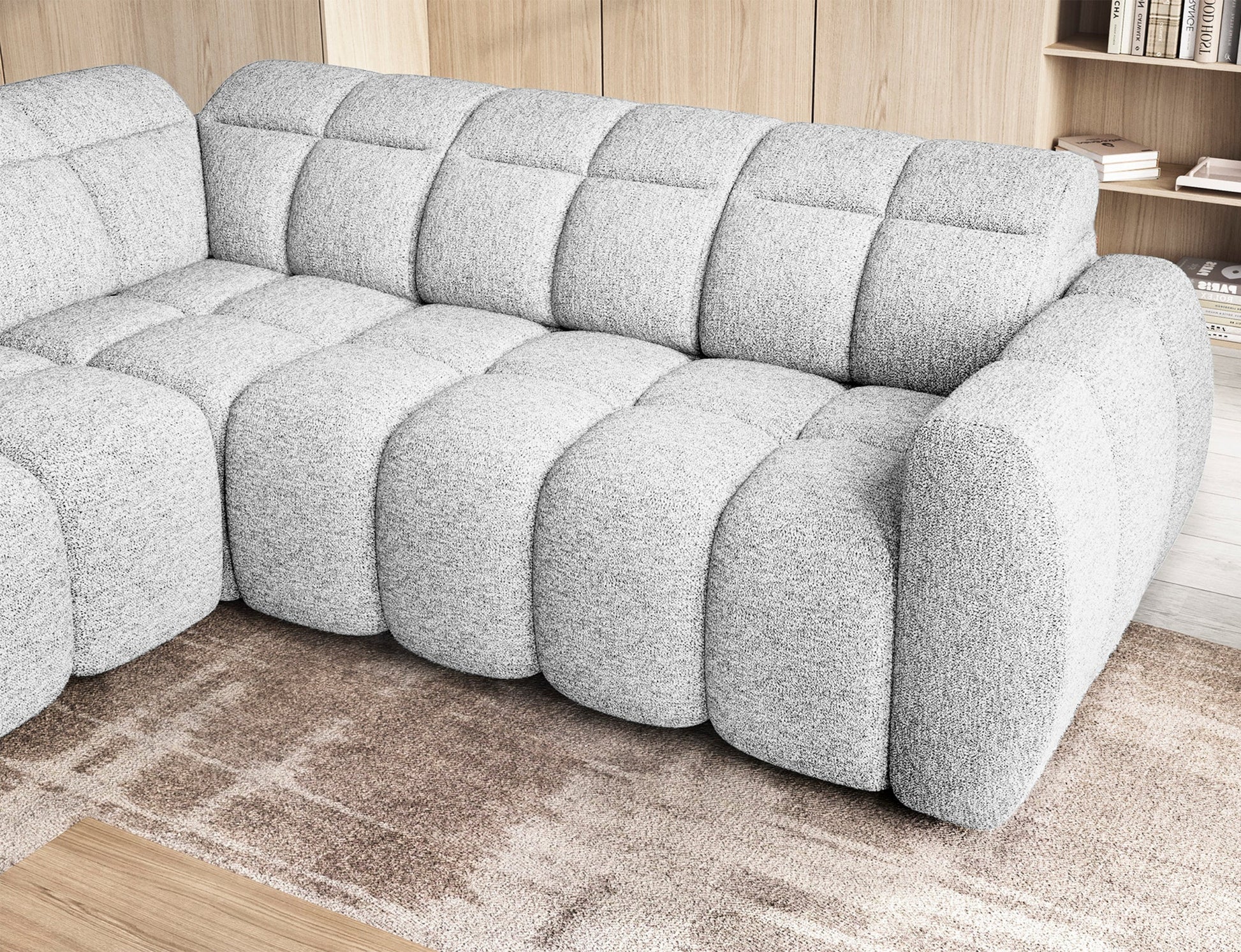 Zbliżenie na narożnik Falconn Coralline 01 z wsuniętym siedziskiem, pokazujące pikowaną strukturę i zaokrąglone linie w tkaninie bouclé.