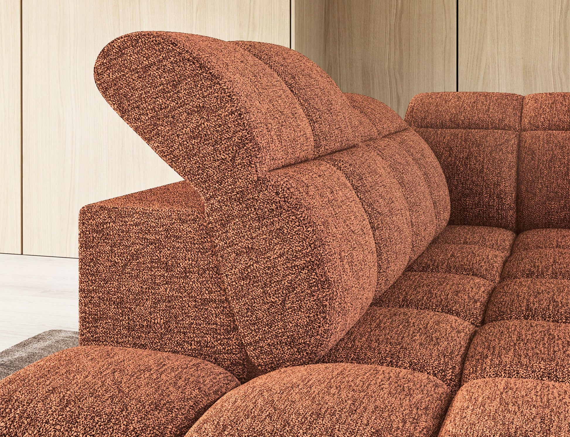 Zbliżenie na narożnik Falconn Coralline 30 w kolorze ceglastym z podniesionym zagłówkiem i tapicerką o wyrazistej fakturze.