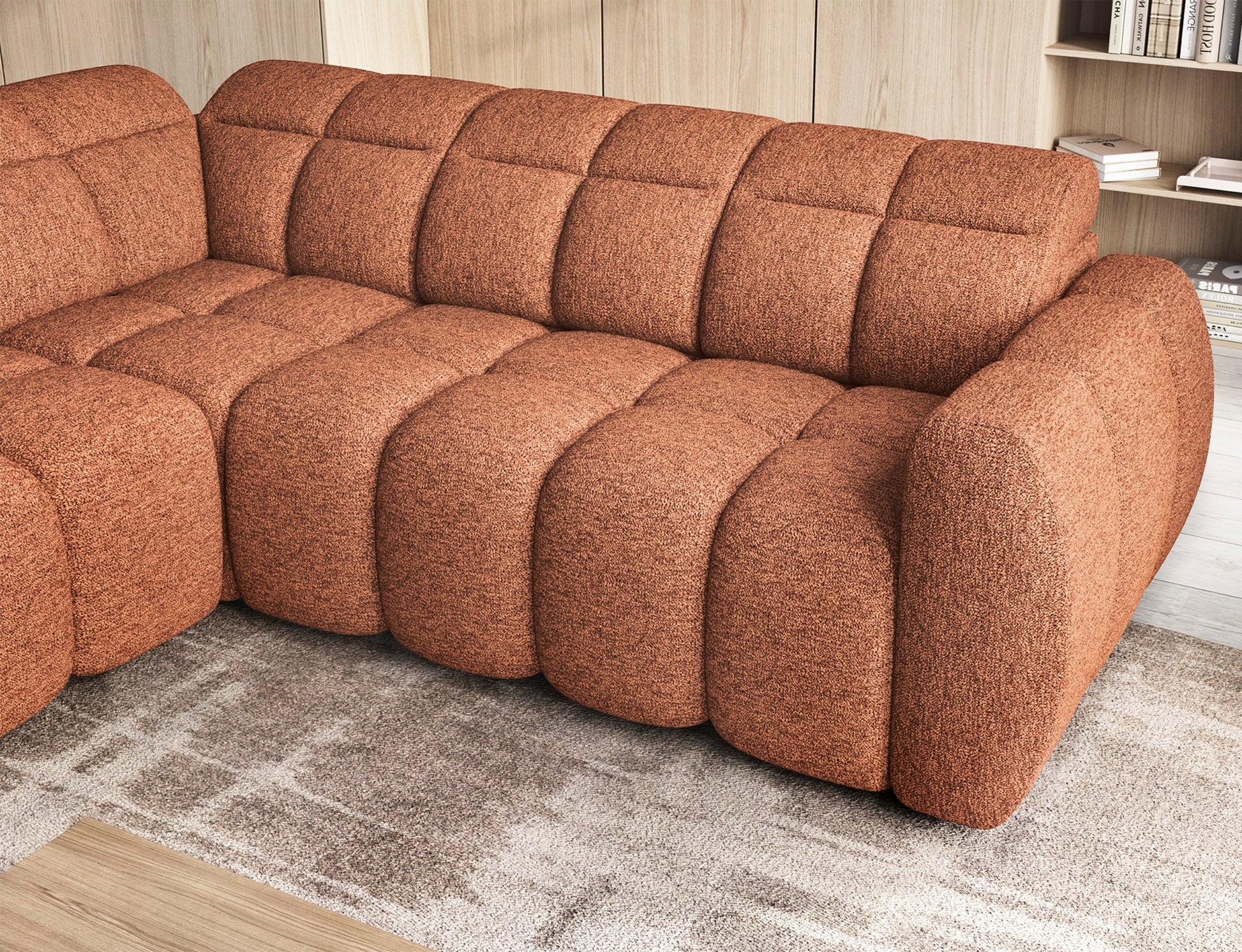 Narożnik Falconn w tkaninie Coralline 30 w kolorze ceglanym – zbliżenie na wsunięte siedzisko i detale przeszyć w aranżacji salonu.