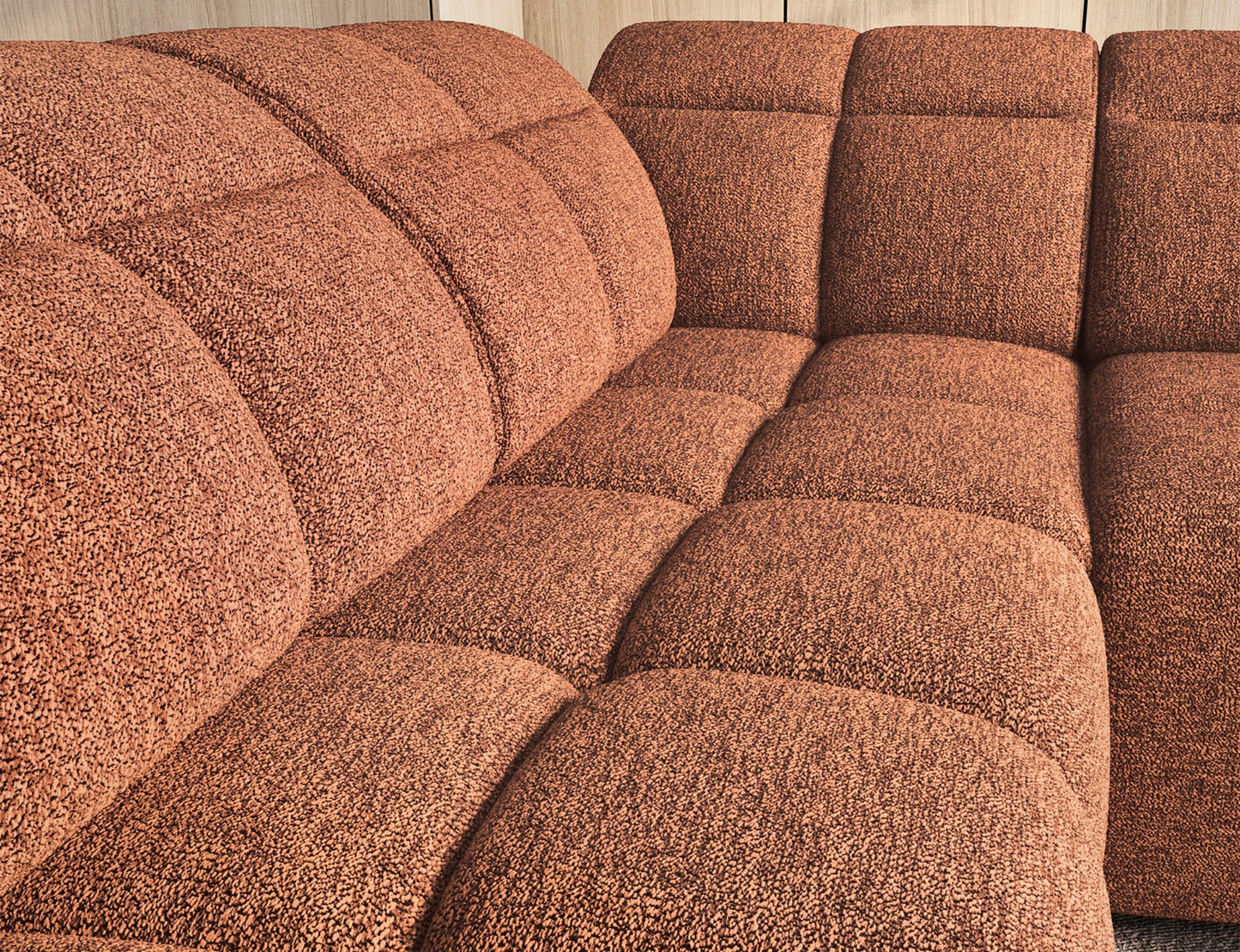 Zbliżenie na ceglasty narożnik Falconn Coralline 30 z miękkim, pikowanym siedziskiem o wyrazistej fakturze i nowoczesnym designie.