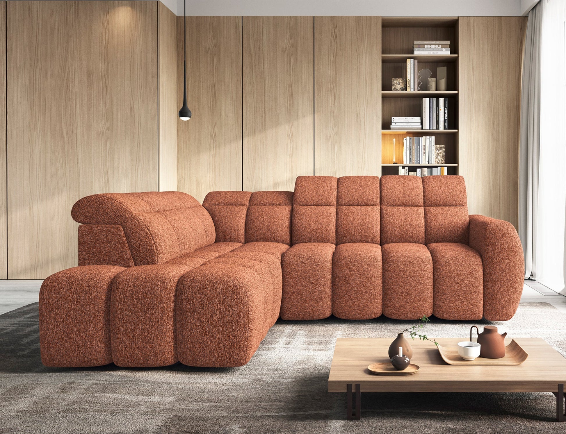 Narożnik Falconn w przestronnym salonie z drewnianymi panelami i biblioteczką, widok z przodu z wyeksponowanym bokiem i zagłówkiem.