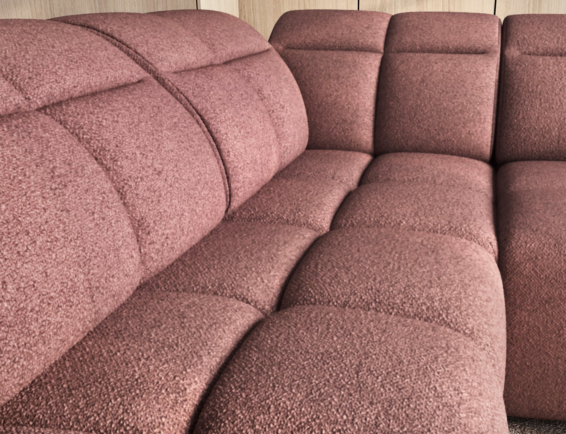 Zbliżenie na różowe siedzisko narożnika Falconn Paolli 24, widoczne pikowane poduszki, tło z jasnym drewnem i regałem.