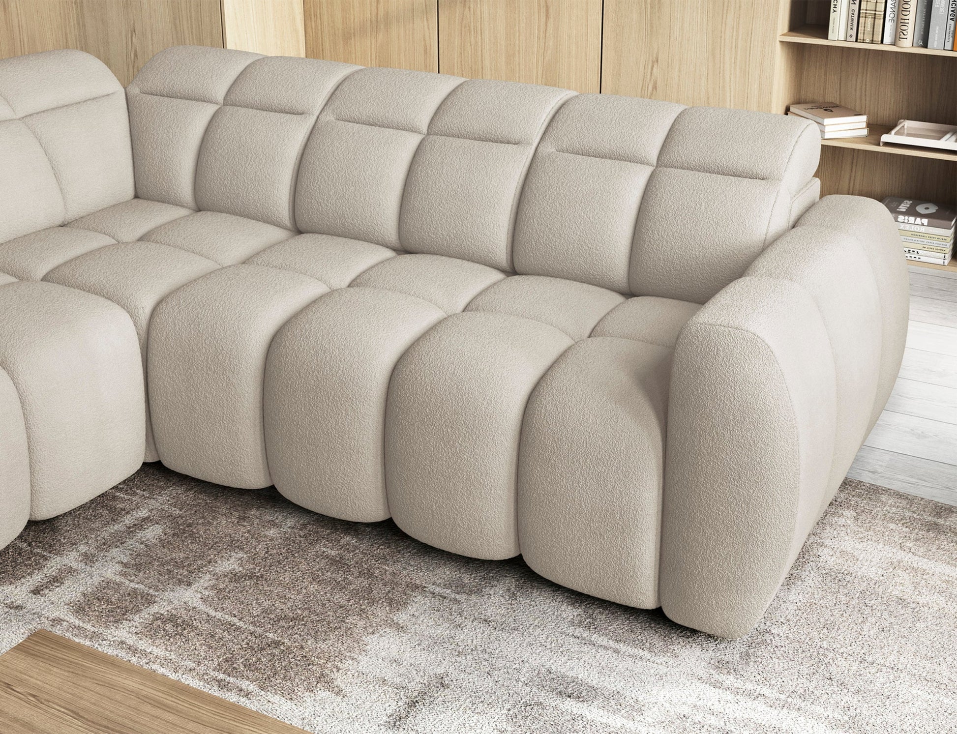 Zbliżenie na siedzisko narożnika Falconn Royal 18 w beżowym kolorze, tapicerka boucle, miękkie pikowanie, nowoczesne wnętrze.