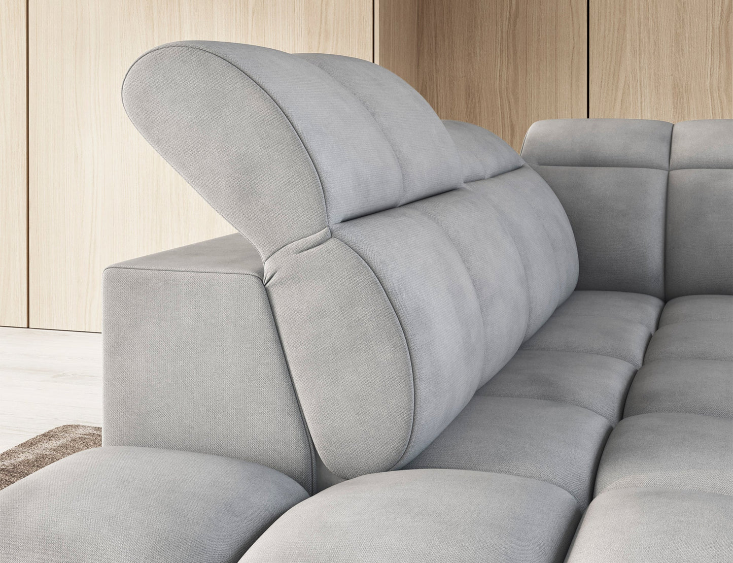 Jasnoszary narożnik Falconn Sola 04 z podniesionym zagłówkiem i pikowanym oparciem, w nowoczesnym wnętrzu z drewnianymi panelami ściennymi.