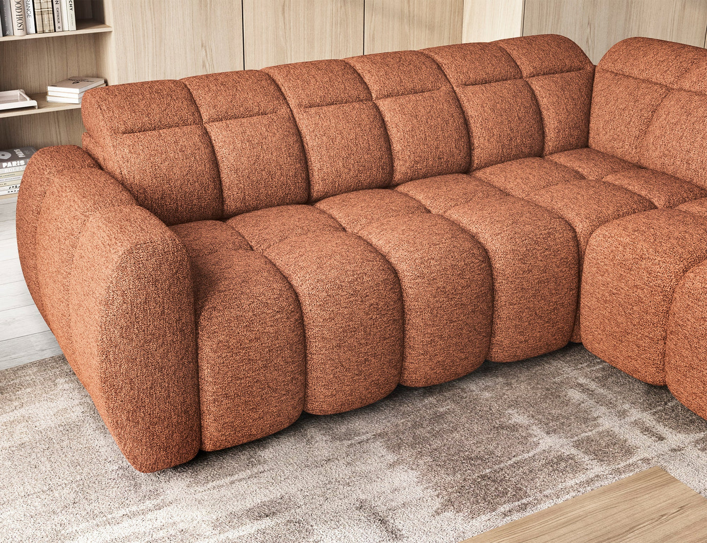 Zbliżenie na siedzisko narożnika Falconn w kolorze ceglastym, z widoczną zaokrągloną linią oparcia i pikowanymi modułami.