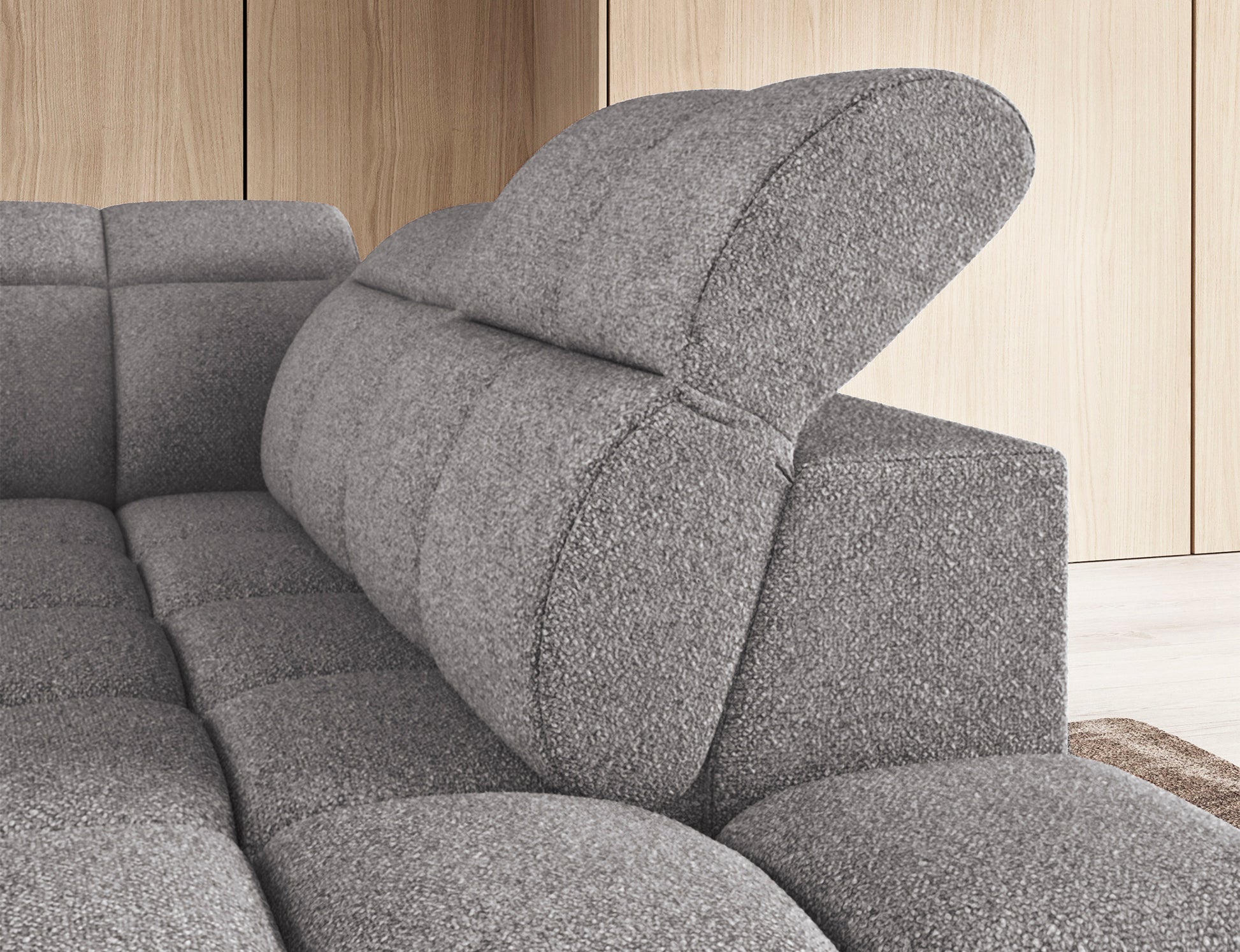 Zbliżenie na regulowany zagłówek narożnika Falconn w tkaninie Paolli 04, prezentujący wygodną formę oparcia w odcieniu szarości.