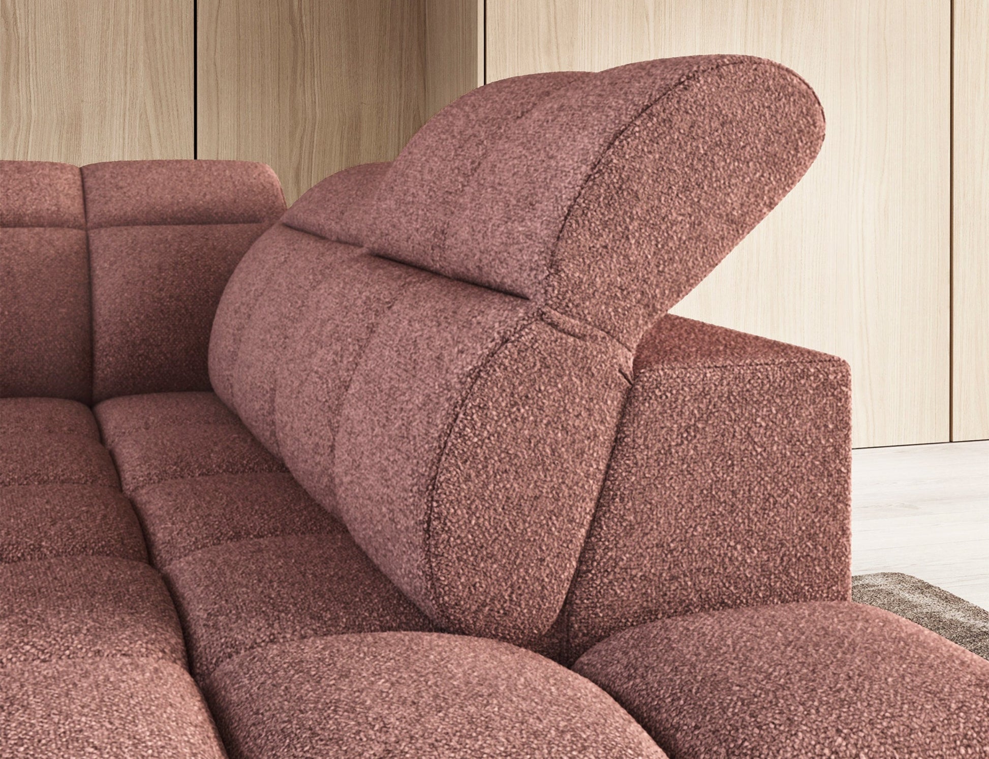 Zbliżenie na boczny profil narożnika Falconn Paolli 24 w różowej tkaninie, ukazujące zaokrąglone linie podłokietnika i panel sterowania.