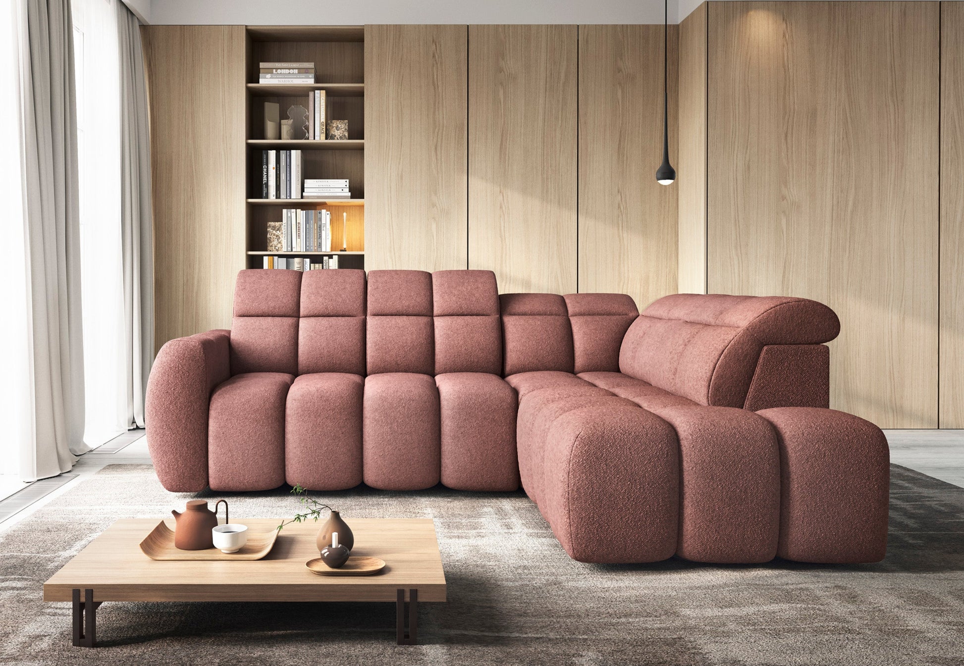 Nowoczesny narożnik Falconn w różowej tkaninie Paolli 24 w aranżacji salonu, z miękkimi siedziskami, zagłówkami i niskim stolikiem.