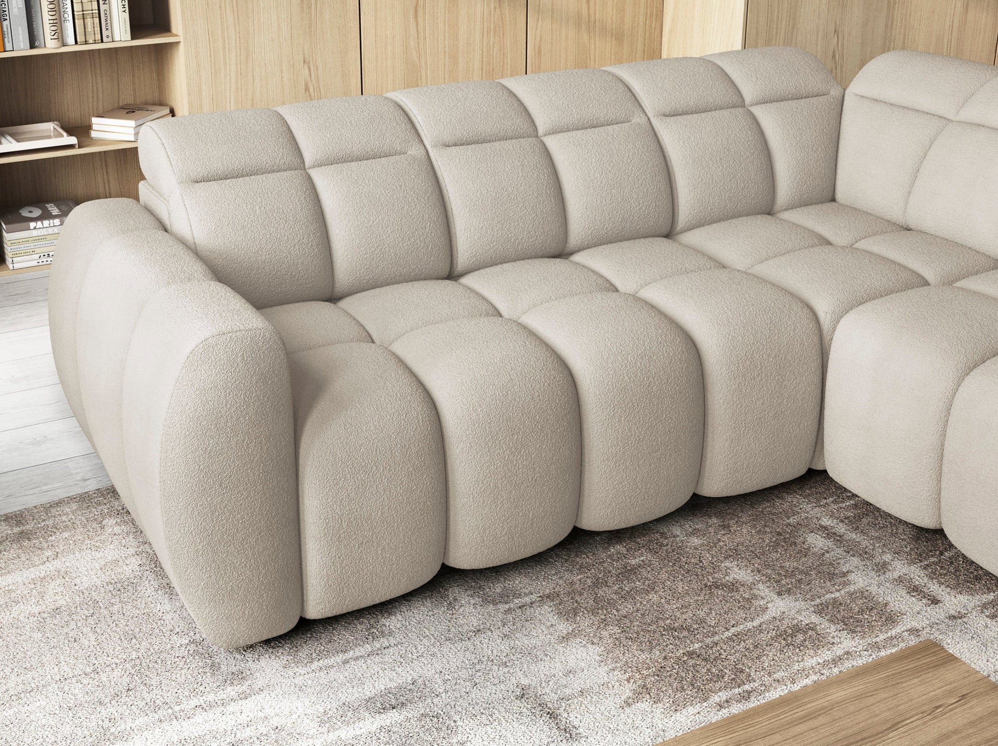 Zbliżenie na narożnik Falconn Royal-18 w jasnej tkaninie z wsuniętym siedziskiem, widoczne miękkie pikowania i zaokrąglone kształty.