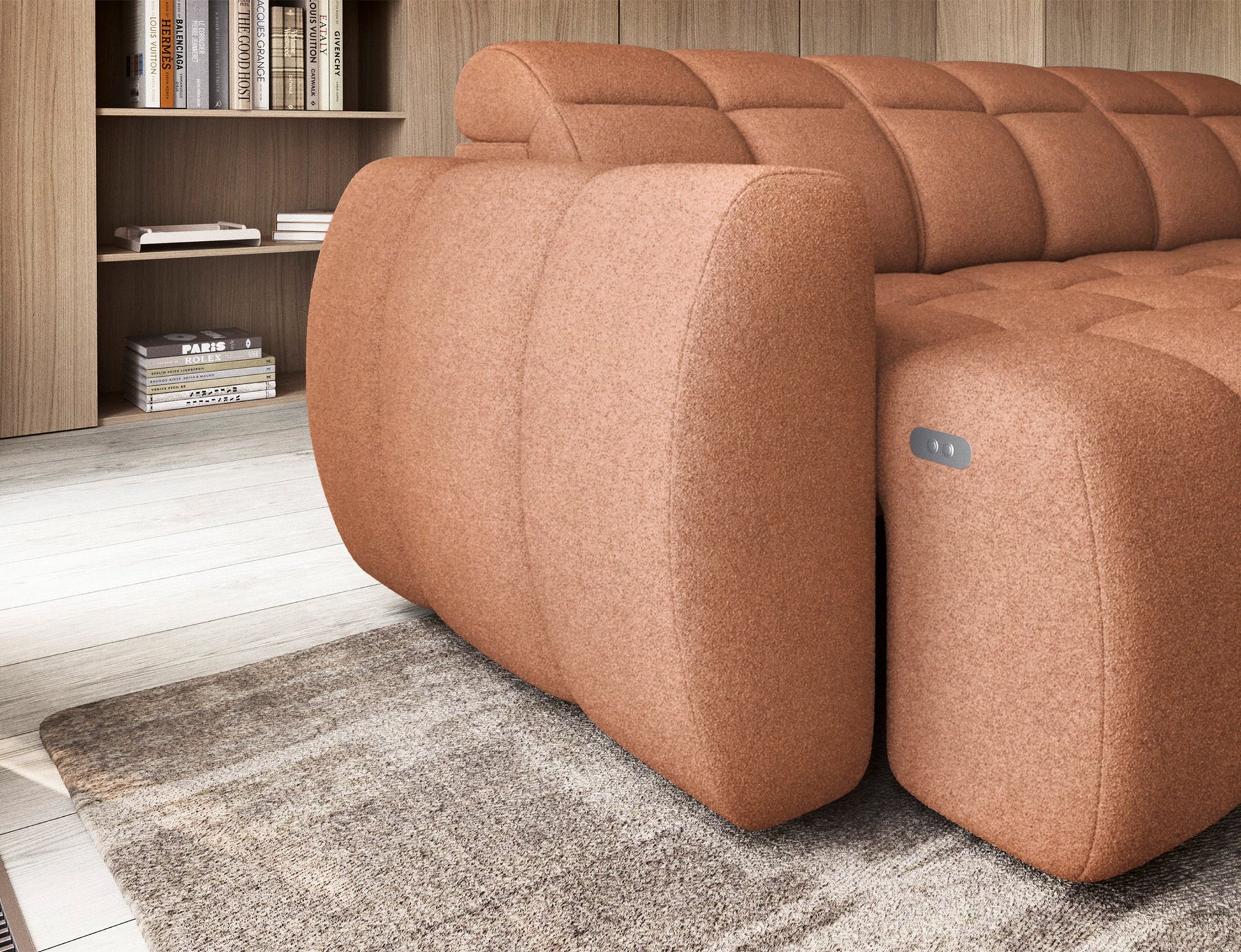 Zbliżenie na boczek narożnika Xillar 24 różowego z przyciskiem sterowania elektrycznego siedziska, na tle jasnej podłogi i regału.