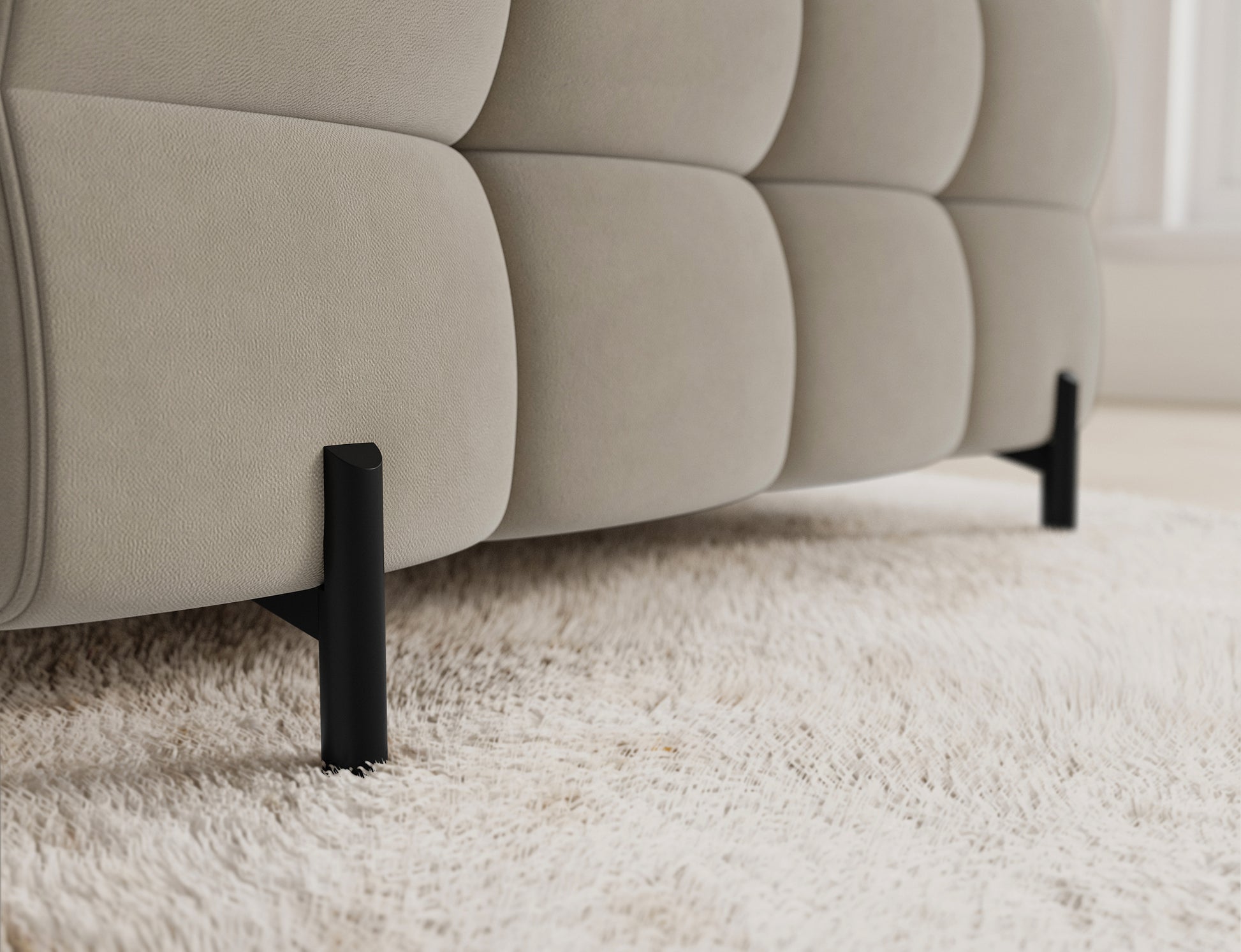 Narożnik Fectory lewy Aura 18 kremowy – detal nogi; smukła, czarna metalowa noga wspierająca całość mebla, elegancki wygląd