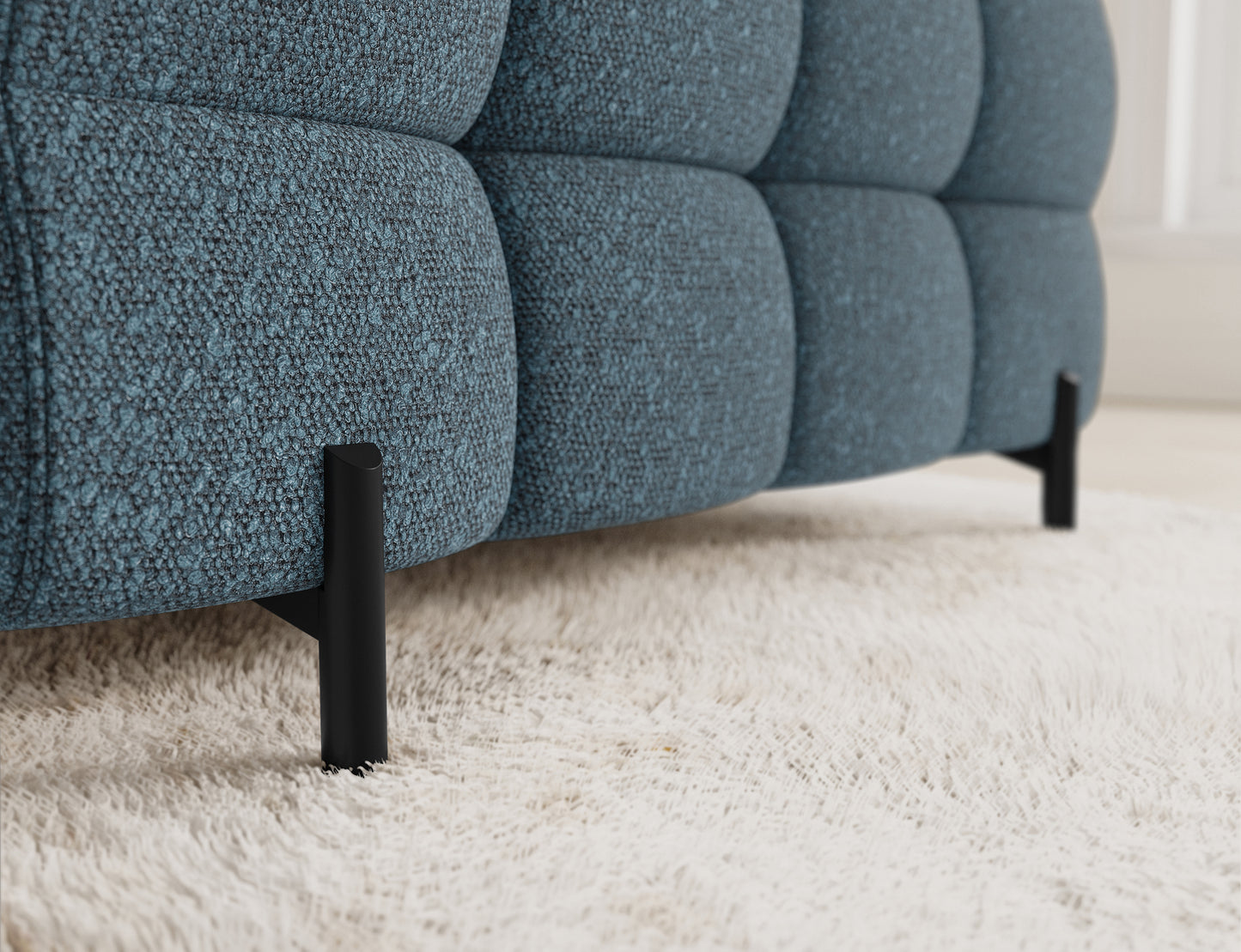 Narożnik Fectory w niebieskim odcieniu, z wyraźnym widokiem na tapicerowaną część i metalowe nogi, podkreślające nowoczesny design.