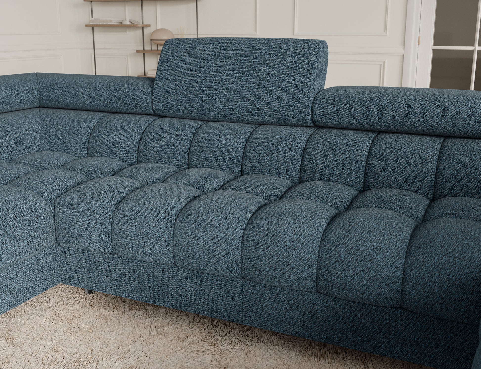 Zbliżenie na narożnik Fectory w niebieskim kolorze, ukazujące detale tapicerki oraz elegancki wygląd mebla z metalowymi nogami.