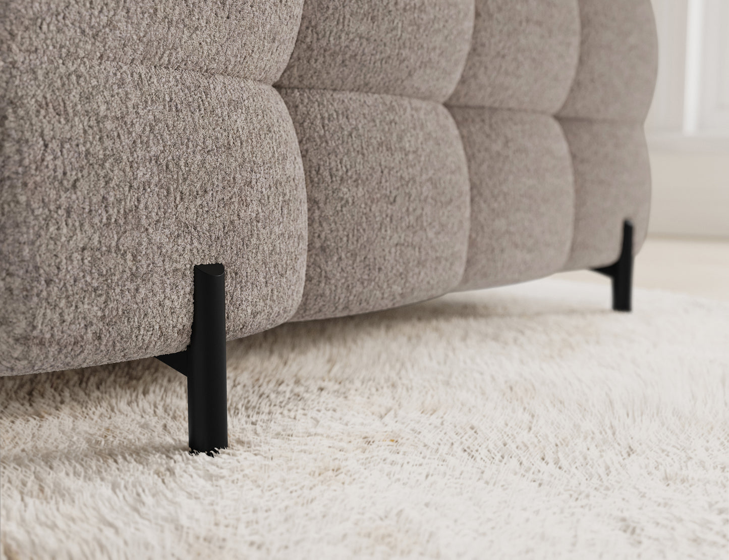 Metalowe nogi jasnobeżowego narożnika Fectory, które stanowią element nowoczesnego wykończenia w każdym salonie.