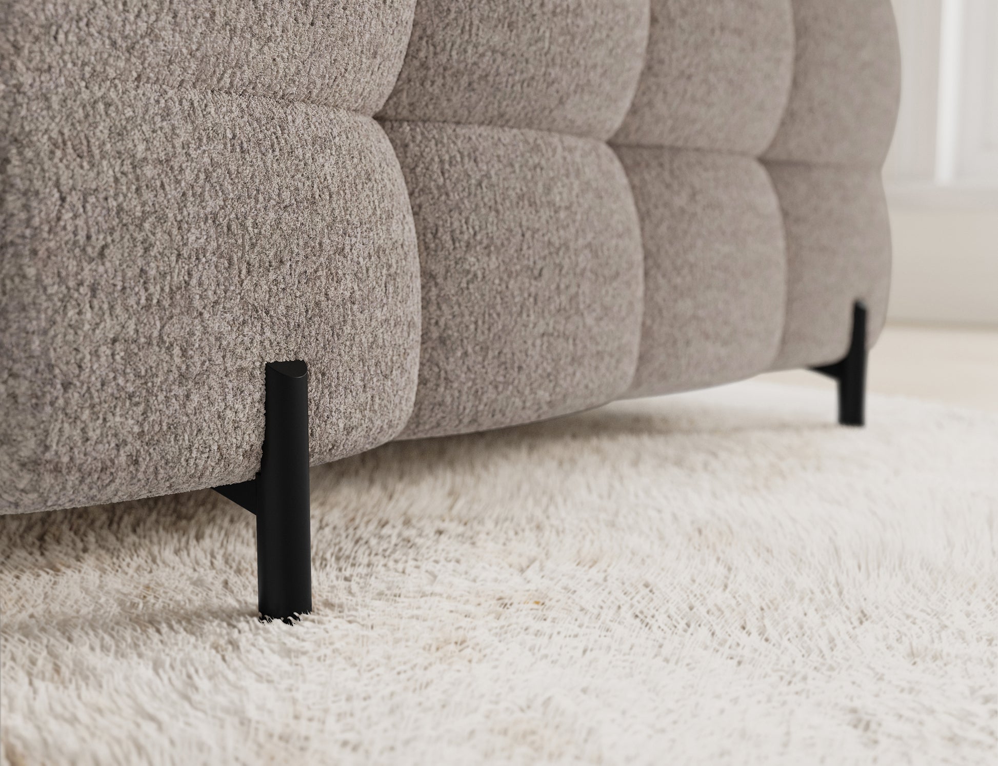 Metalowe nogi jasnobeżowego narożnika Fectory, które stanowią element nowoczesnego wykończenia w każdym salonie.