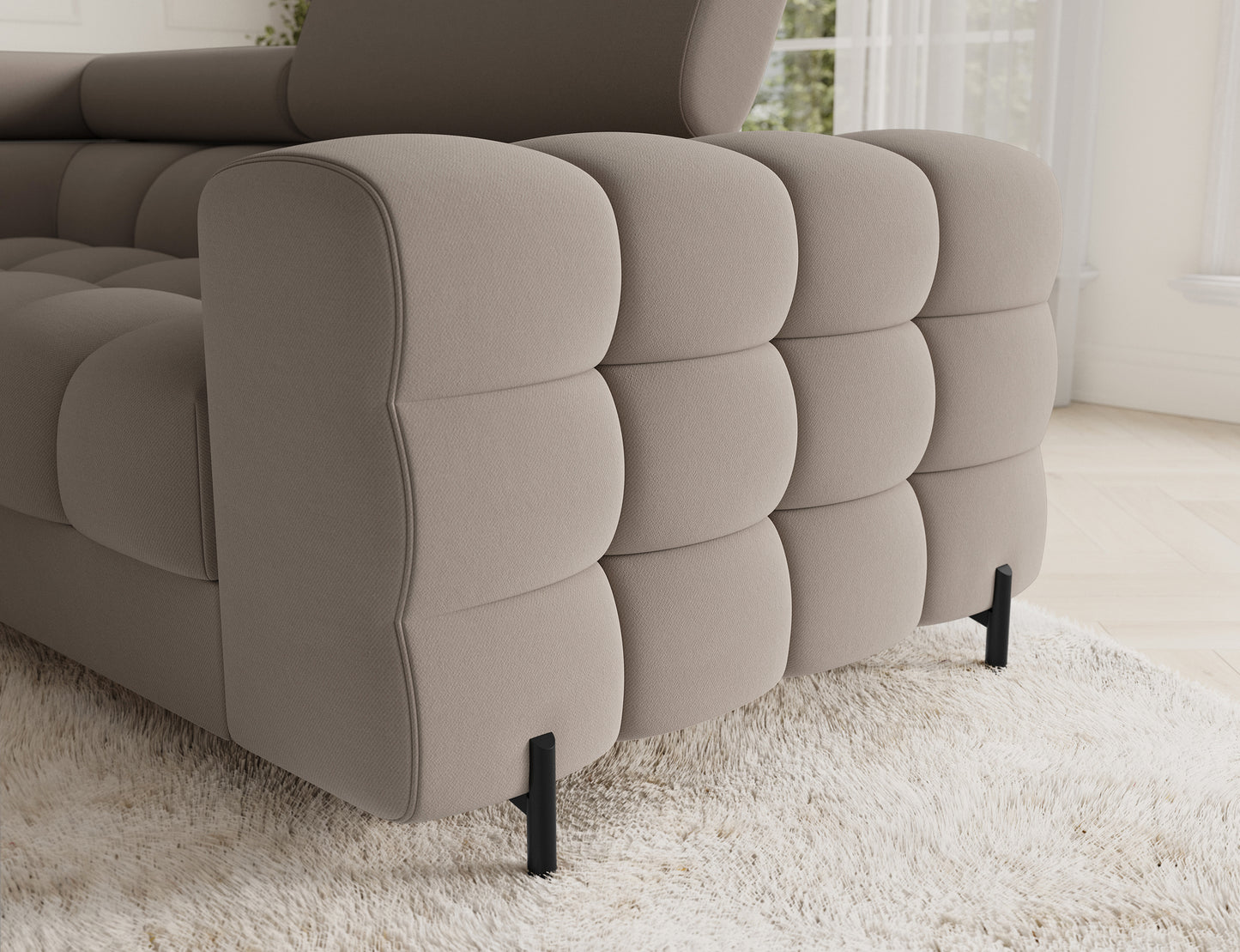 Narożnik z subtelnymi, zaokrąglonymi bokami w odcieniu beżowym. Detal ukazujący eleganckie wykończenie oraz praktyczność mebla.